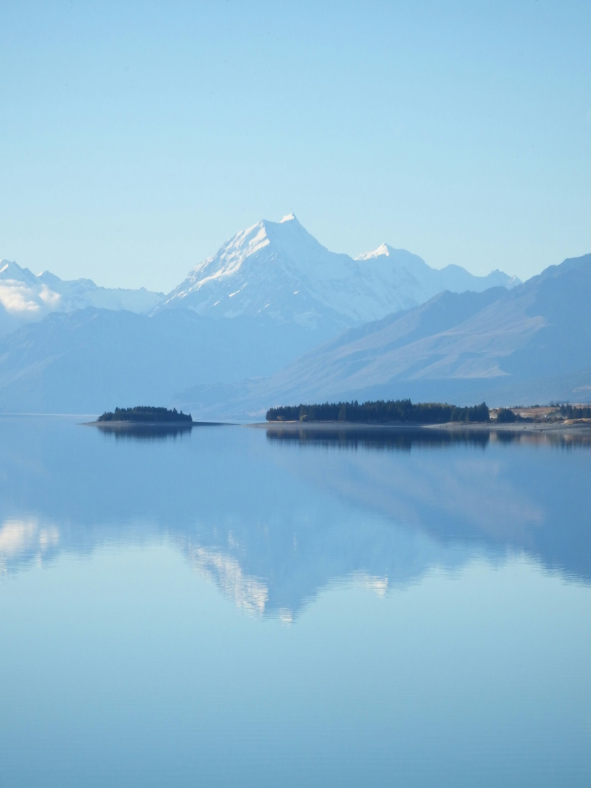Lake Pukaki with Mount Cook in the background and a small island in the middle in New Zealand.