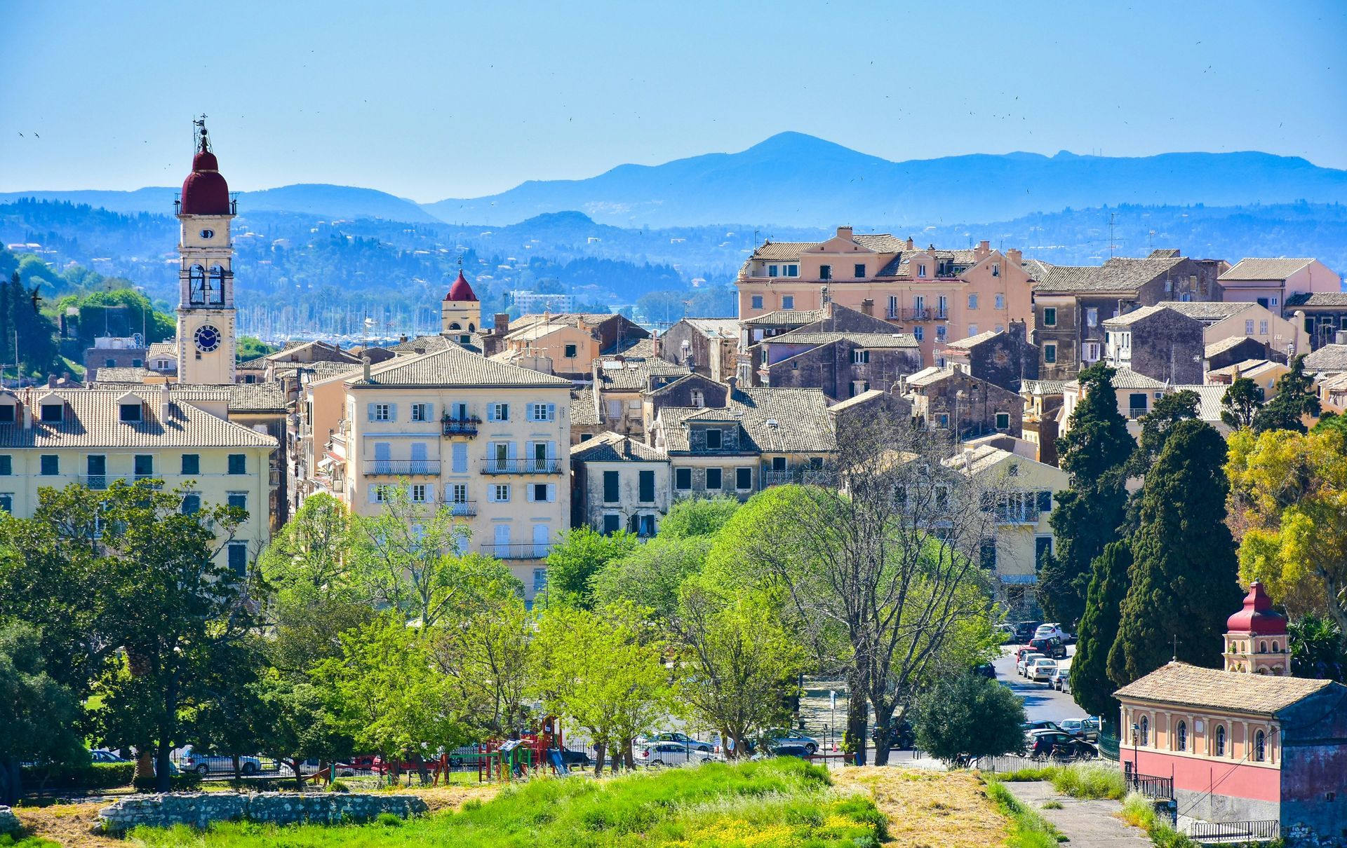 An aerial view of a city with mountains in the background in Corfu, Greece.