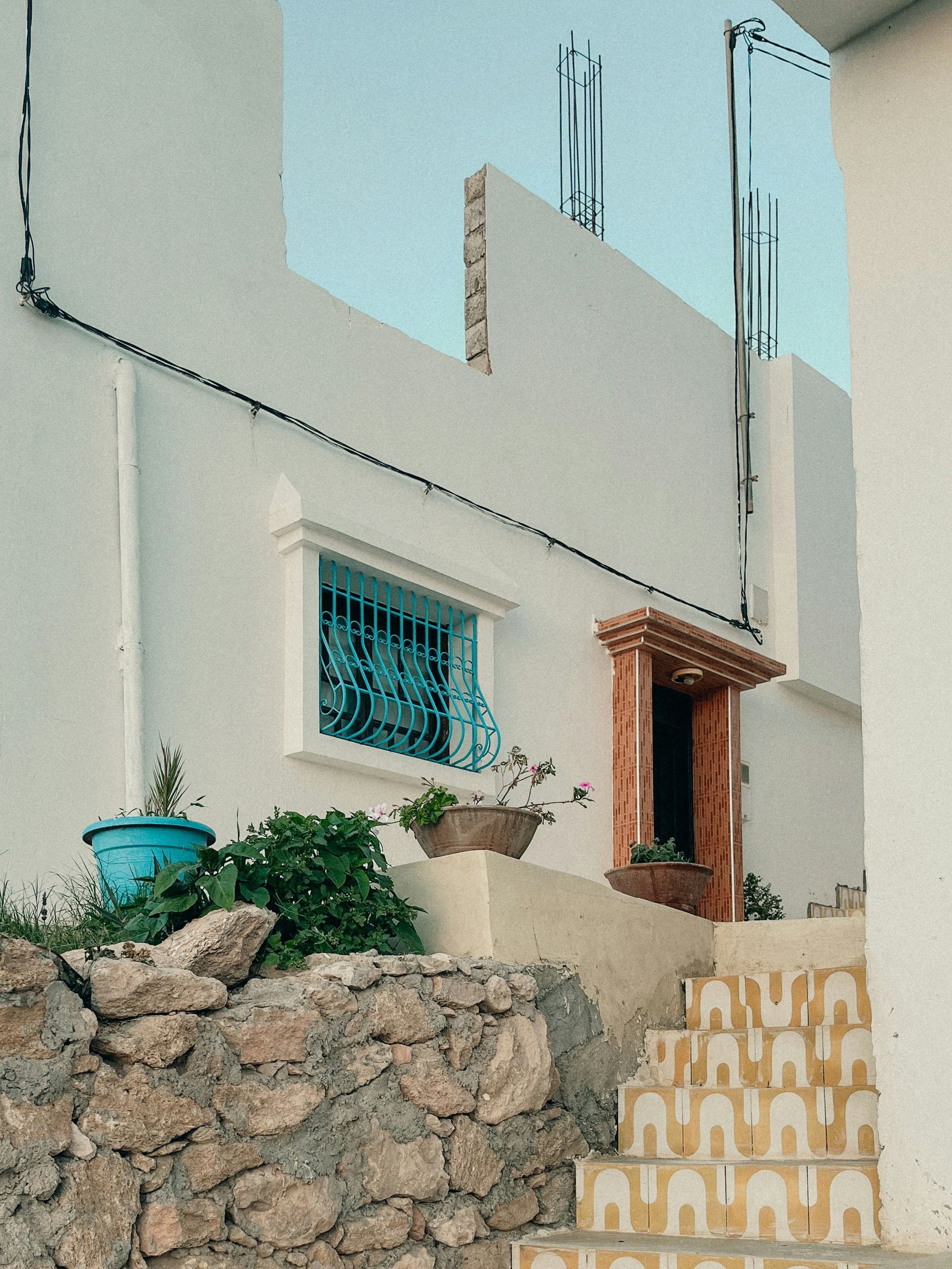 A white building with stairs leading up to it in Taghazout, Morocco.