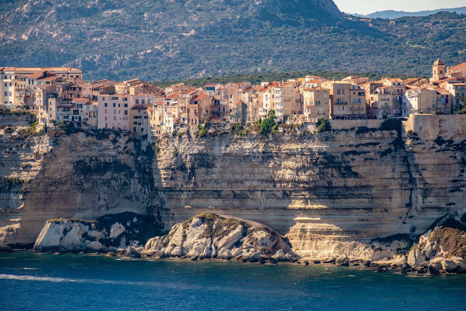The city of Bonifacio is sitting on top of a cliff overlooking the ocean in Corsica, France.