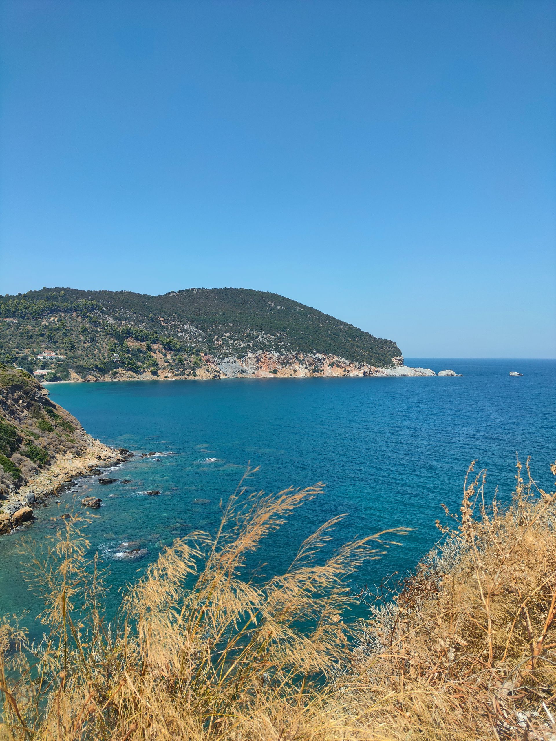 A view of a large body of water with mountains in the background in Skopelos, Greece.