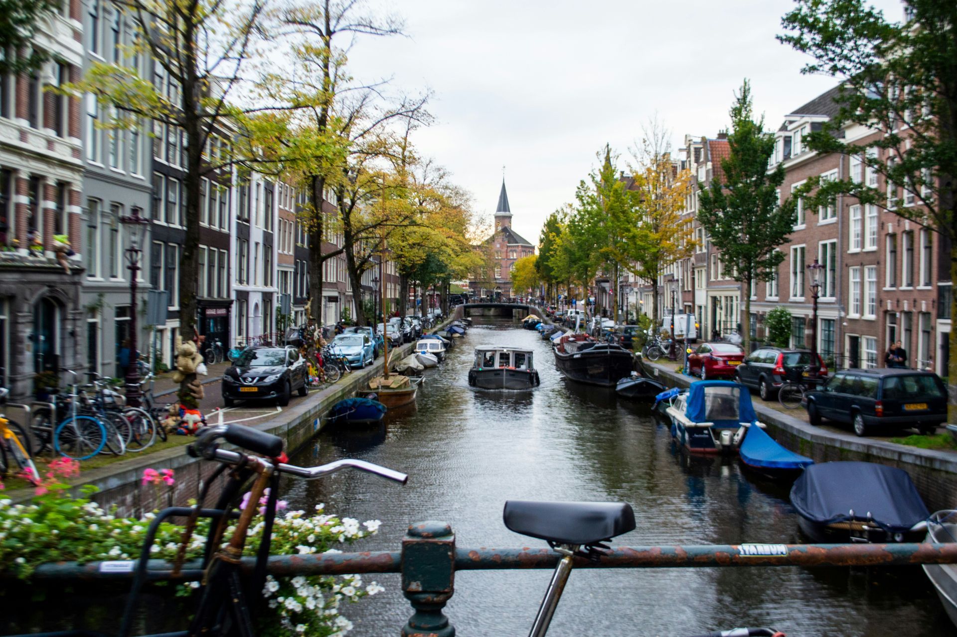 A bicycle is parked on a bridge over a canal in Amsterdam.