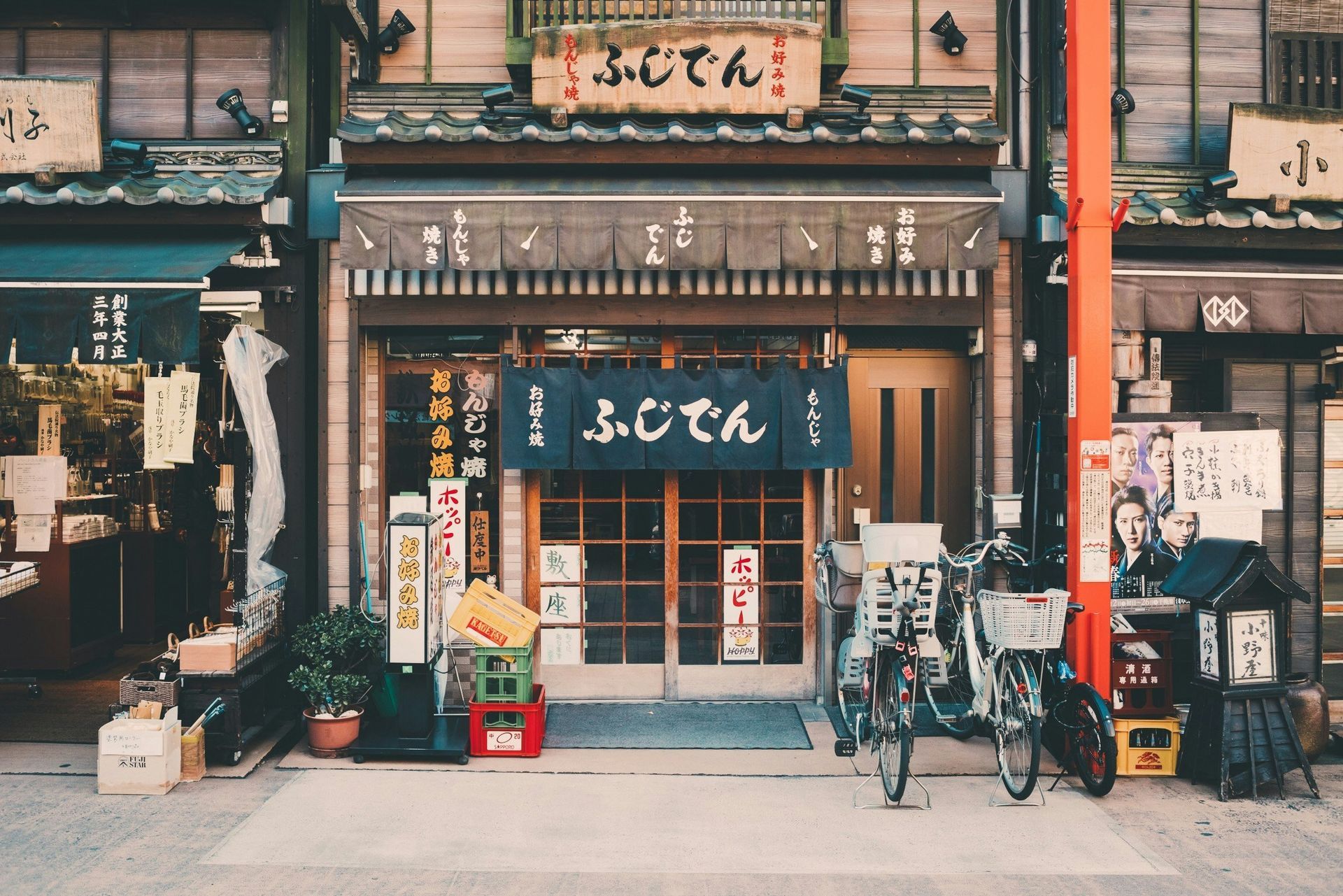 Japanese restaurant facade with bikes, signs, and doorway in Tokyo, Japan.