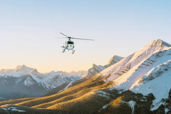 A helicopter is flying over the Icefields in Canada.