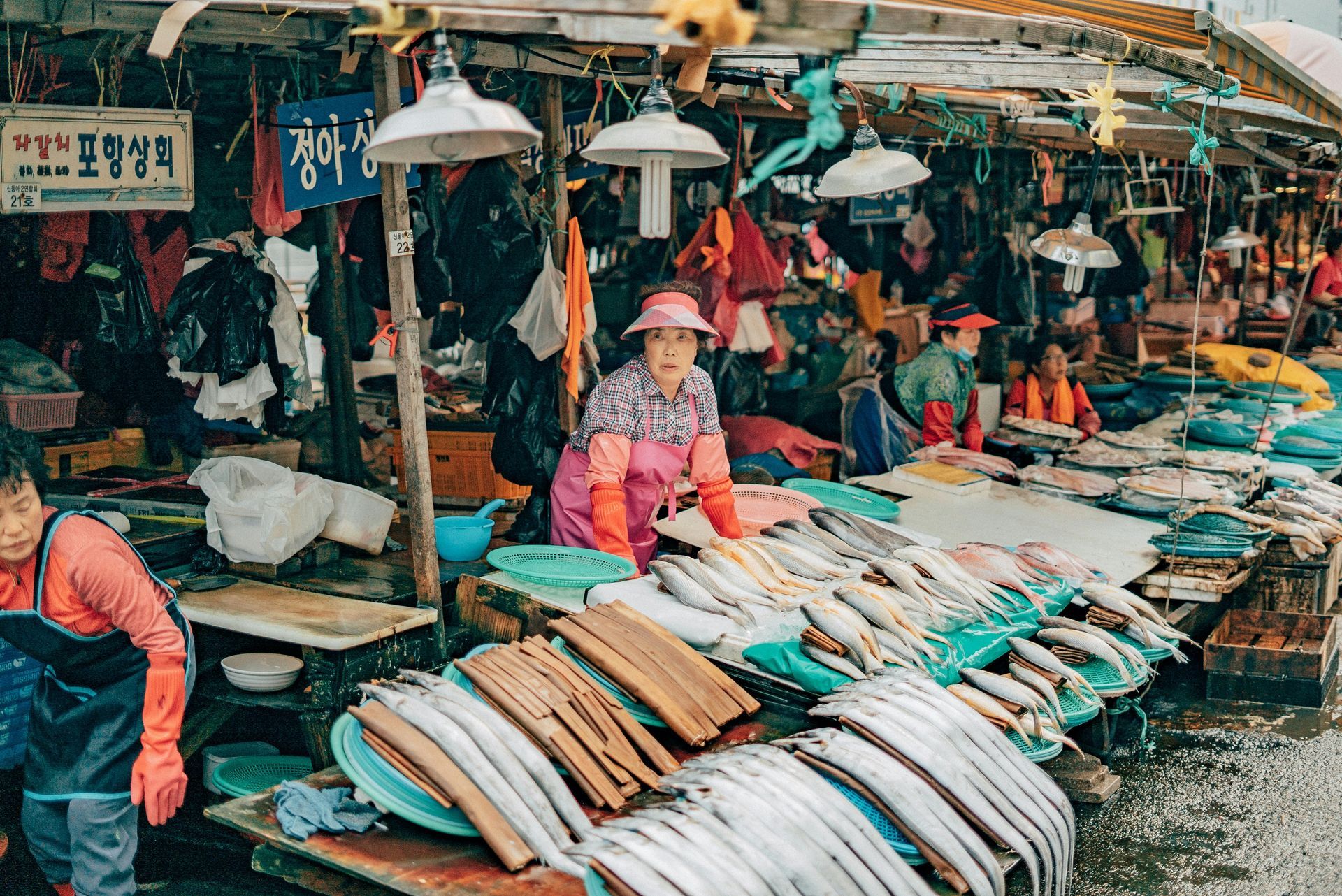 Fish market stall vendors with seafood on display in Busan, South Korea.