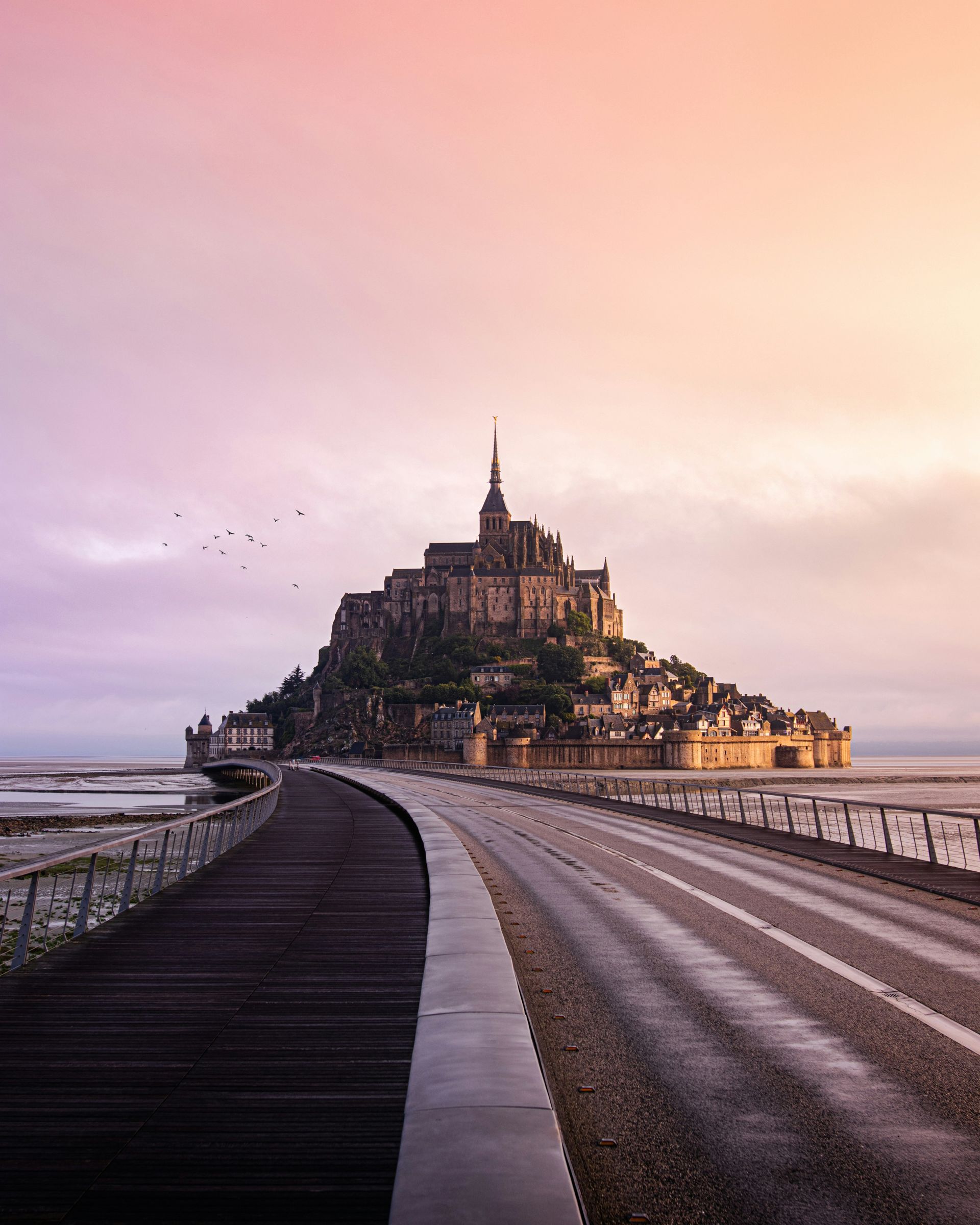 A road leading to Mont Saint-Michel - a castle on top of a hill in Normandy, France.