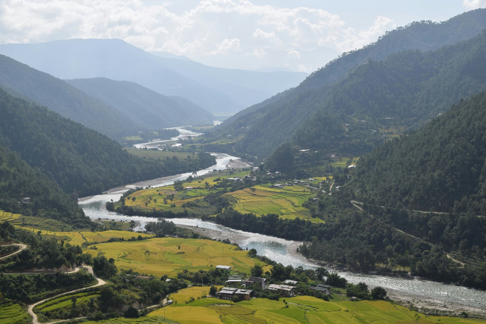 Valley with a winding river, surrounded by green mountains and terraced fields in Punakha, Bhutan.