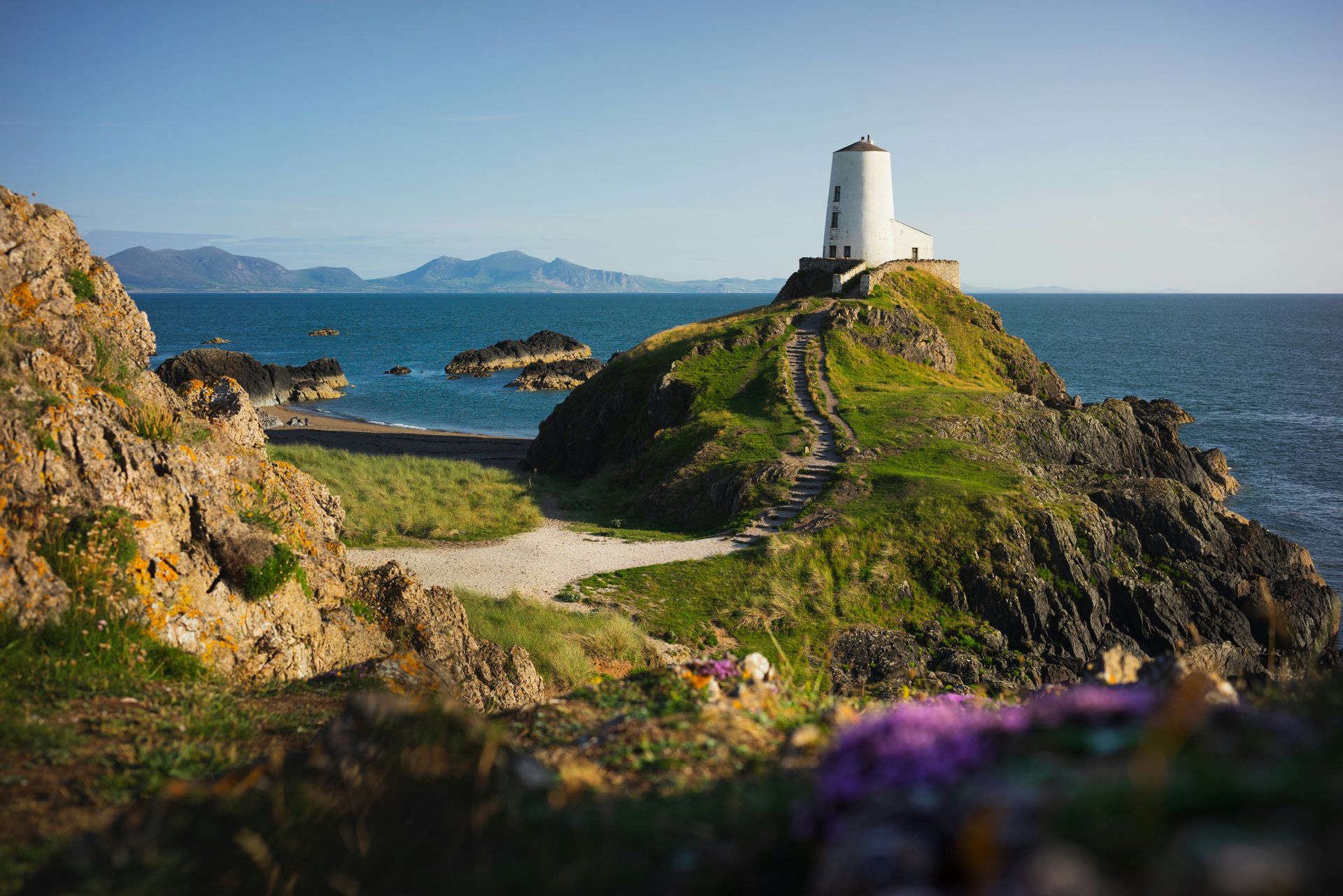 The South Stack Lighthouse on a grassy island, overlooking the sea in Anglesey, Wales