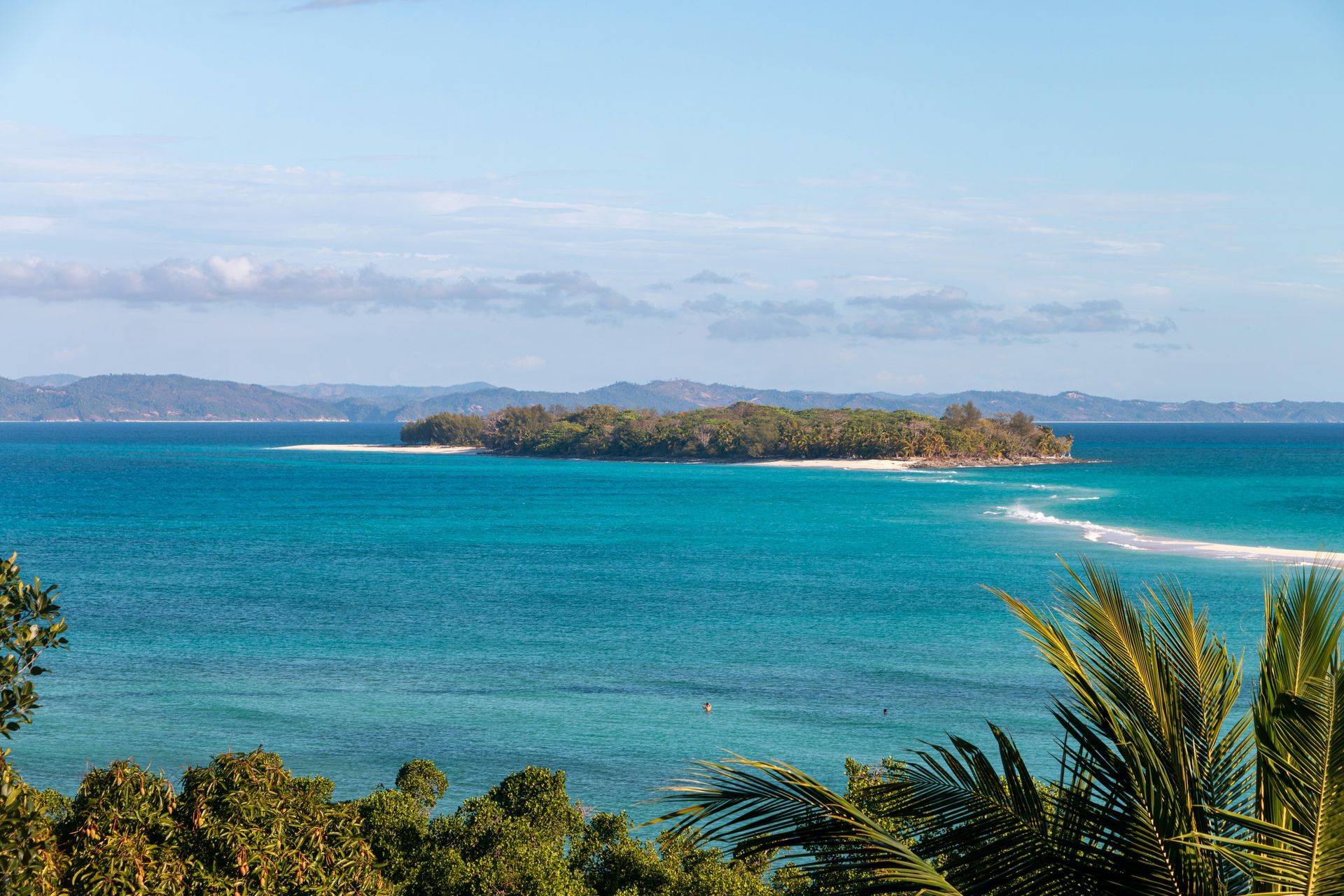 Nosy Iranj Island with lush trees surrounded by turquoise water in Madagascar.