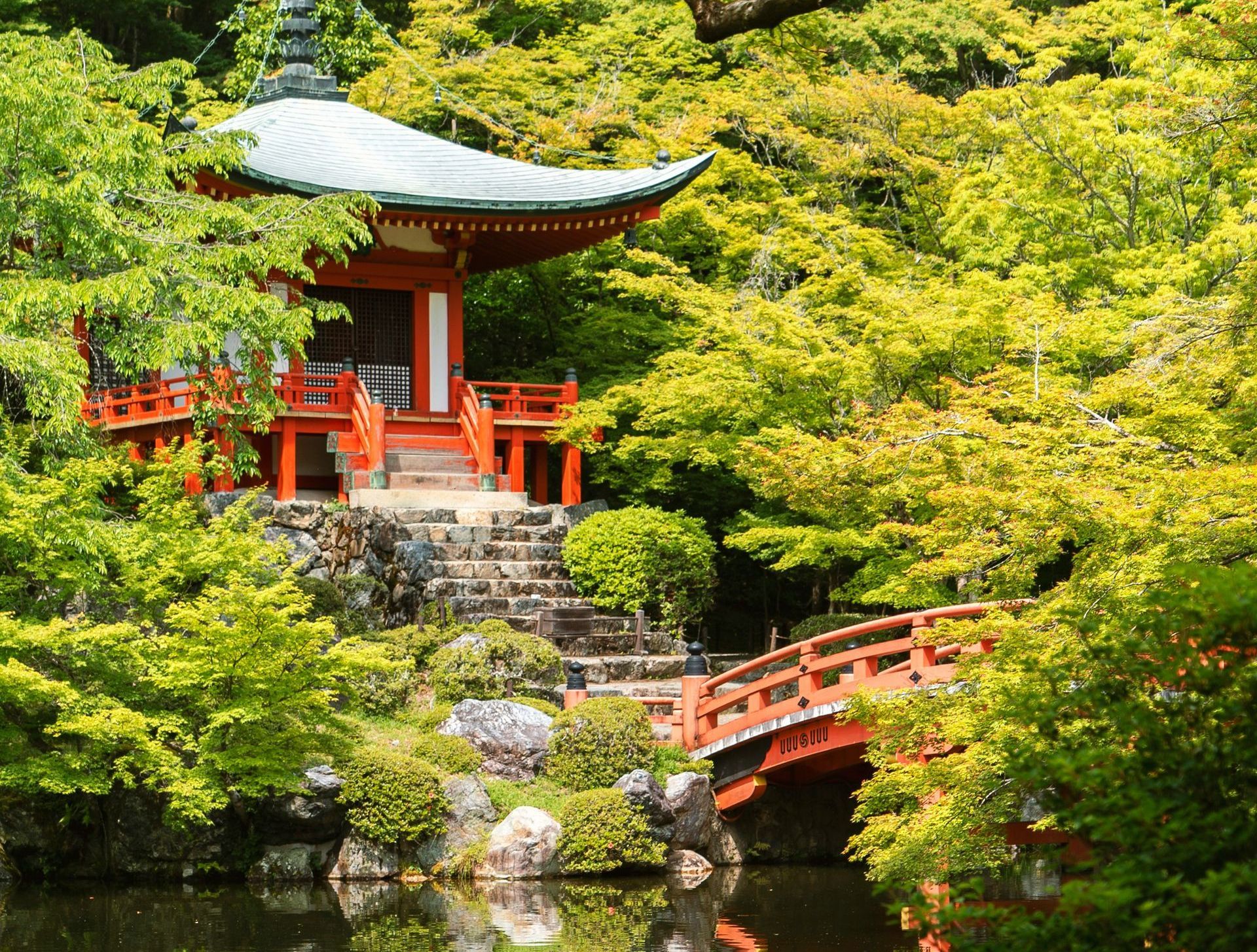 A bridge leading to a temple in the middle of a forest in Japan.