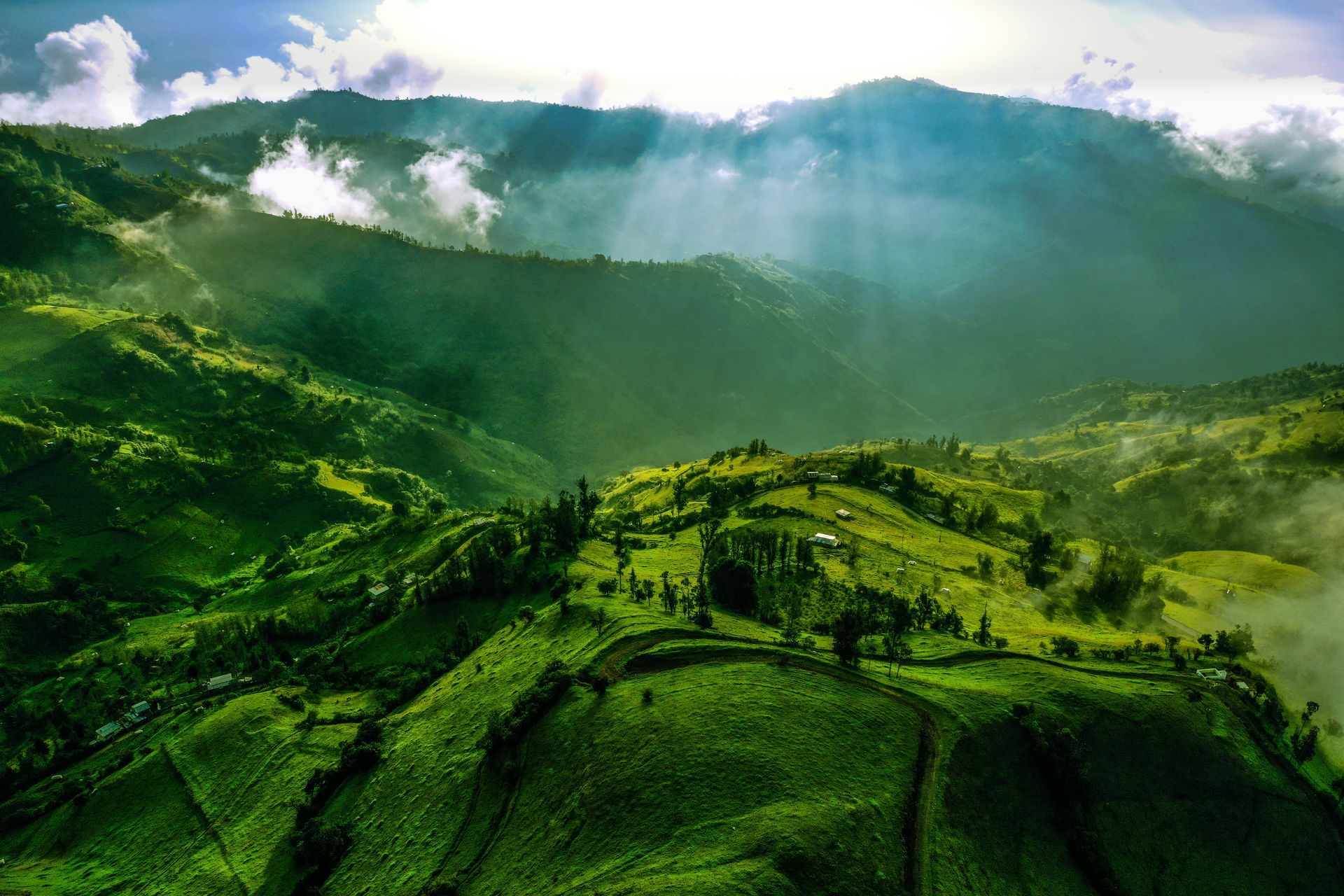 Lush green mountains under sunlight, with beams of light in the Amazon Rainforest of Ecuador.