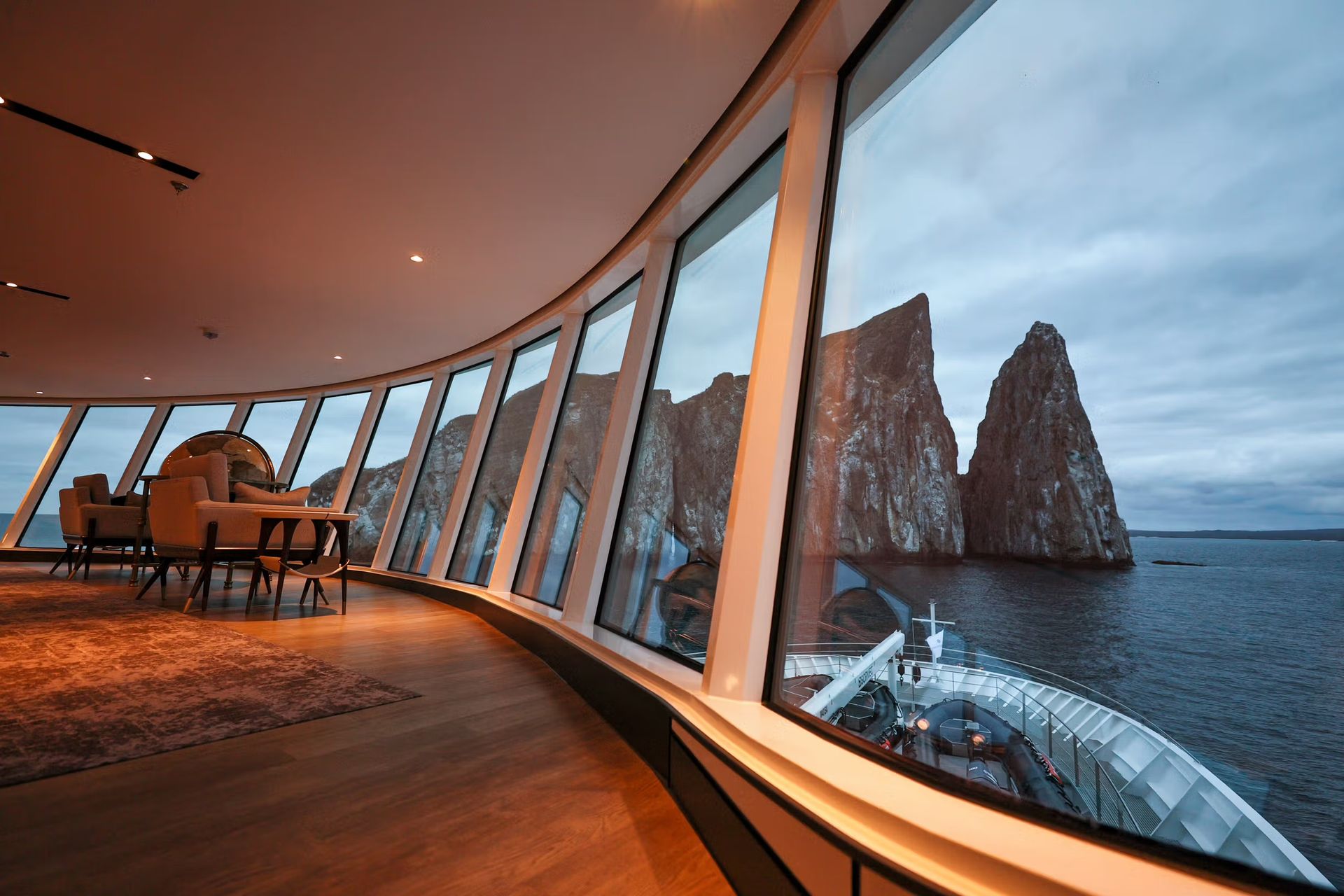 A suite with a lot of windows overlooking the ocean on Silversea's Silver Origin Expedition Cruise Ship.