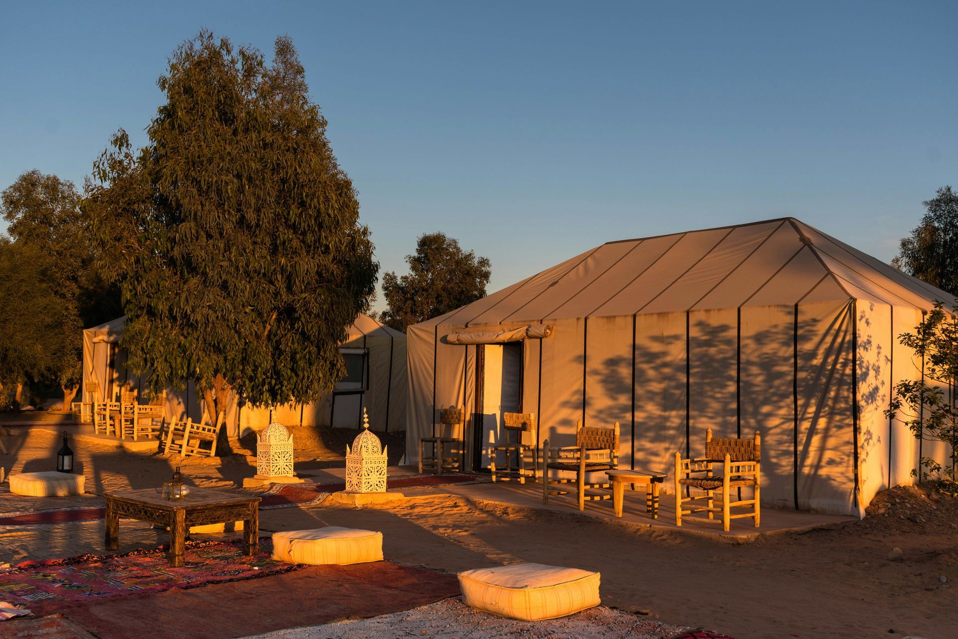 A large tent with chairs and tables in front of it in Erg Chebbi, Morocco.