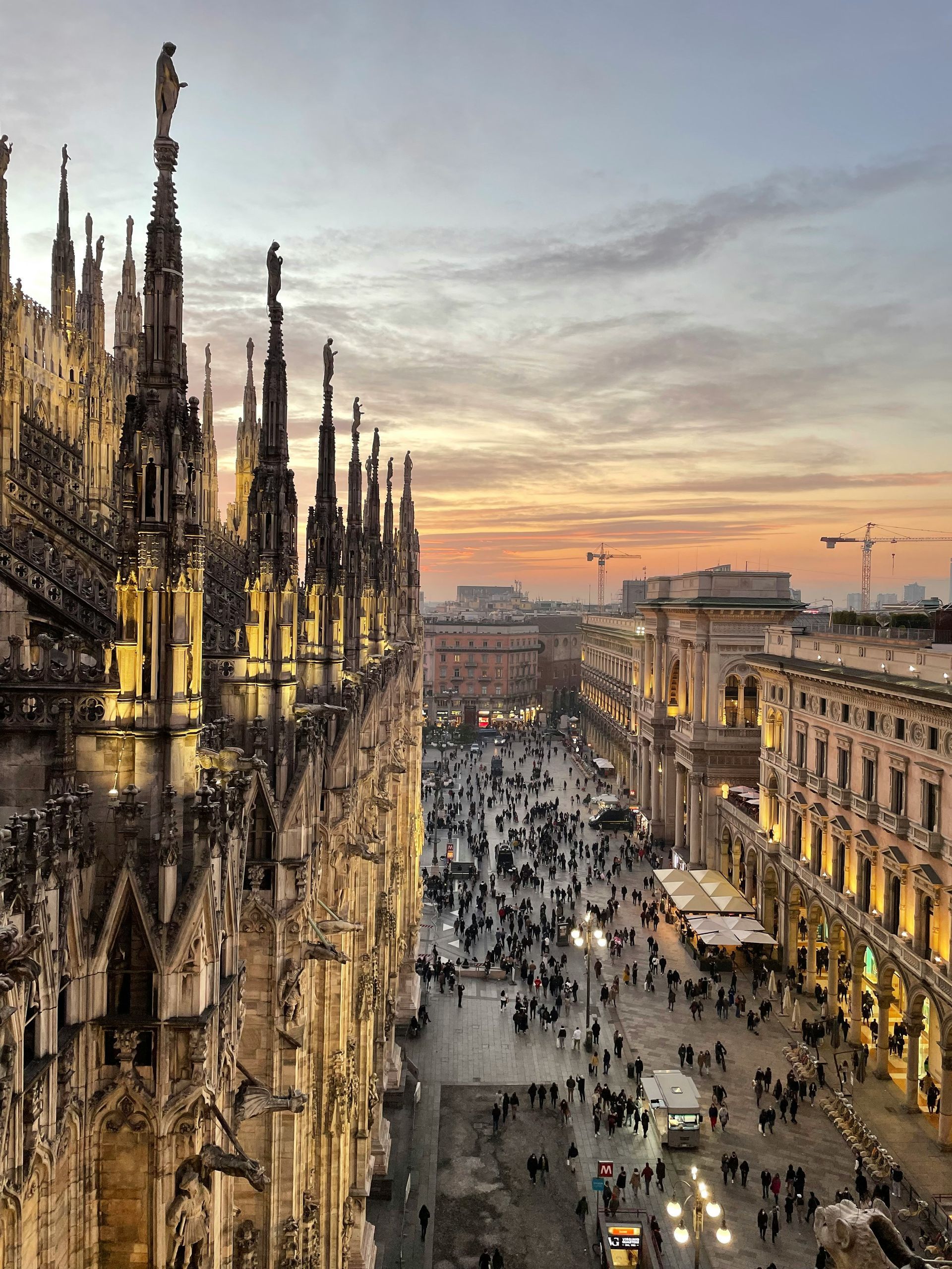An aerial view of Milan at sunset behind the Duomo di Milano.