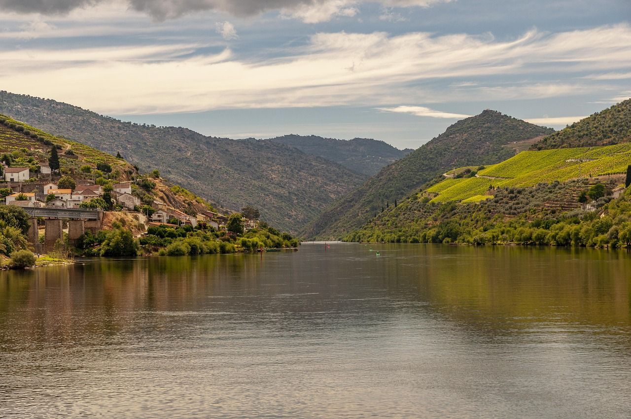 The Douro River is surrounded by mountains on a cloudy day.