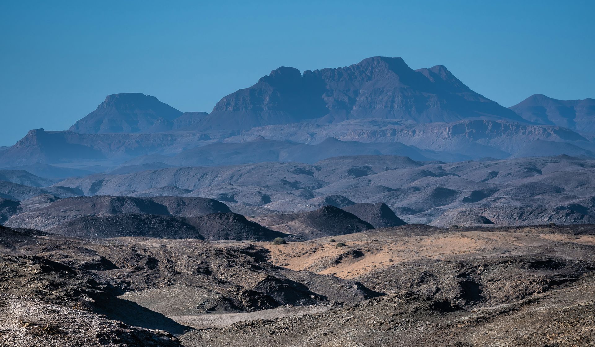 Barren desert landscape with distant mountains in Damaraland, Namibia.