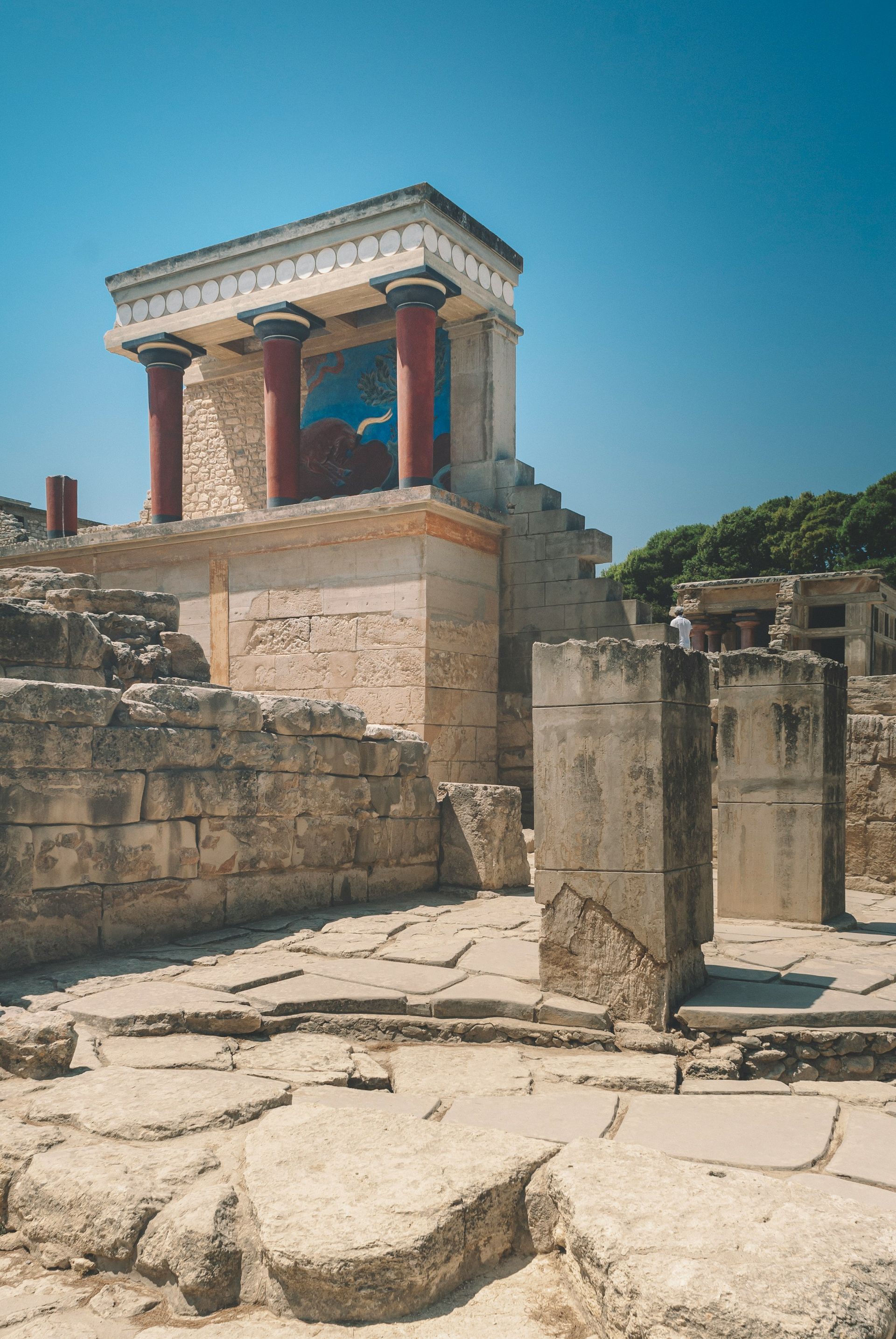 A very old building with columns and a painting on the side of it in Crete, Greece.