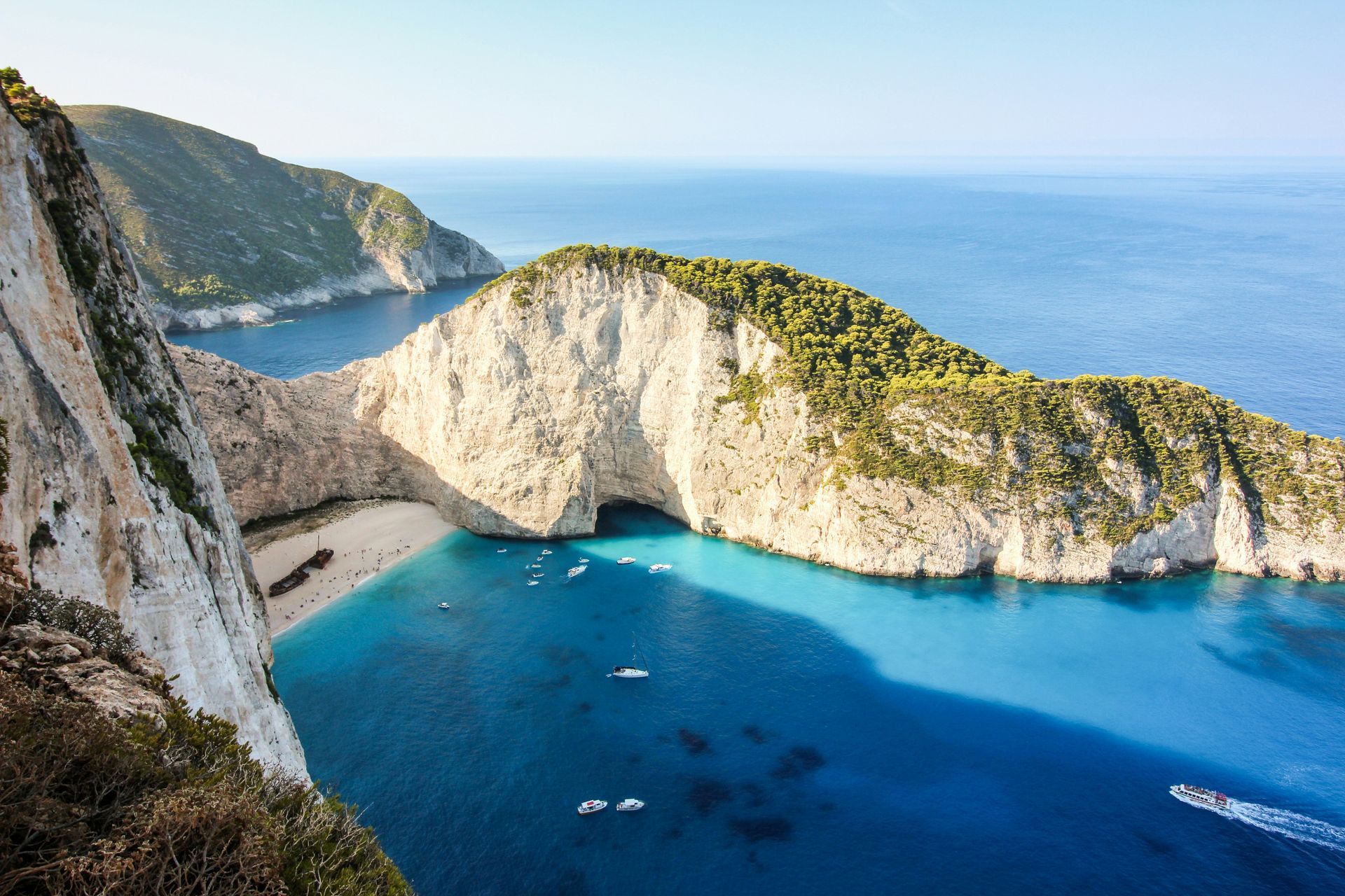 Zakynthos, Greece in the middle of the ocean with a boat in the water.