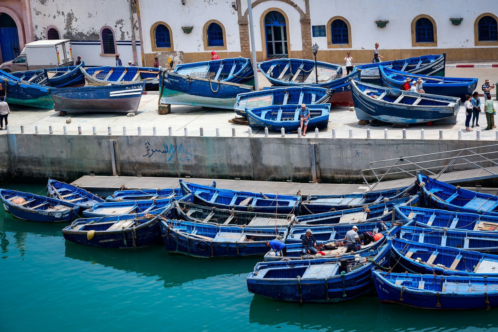 A bunch of blue boats are docked in a harbor in Essaouira, Morocco.