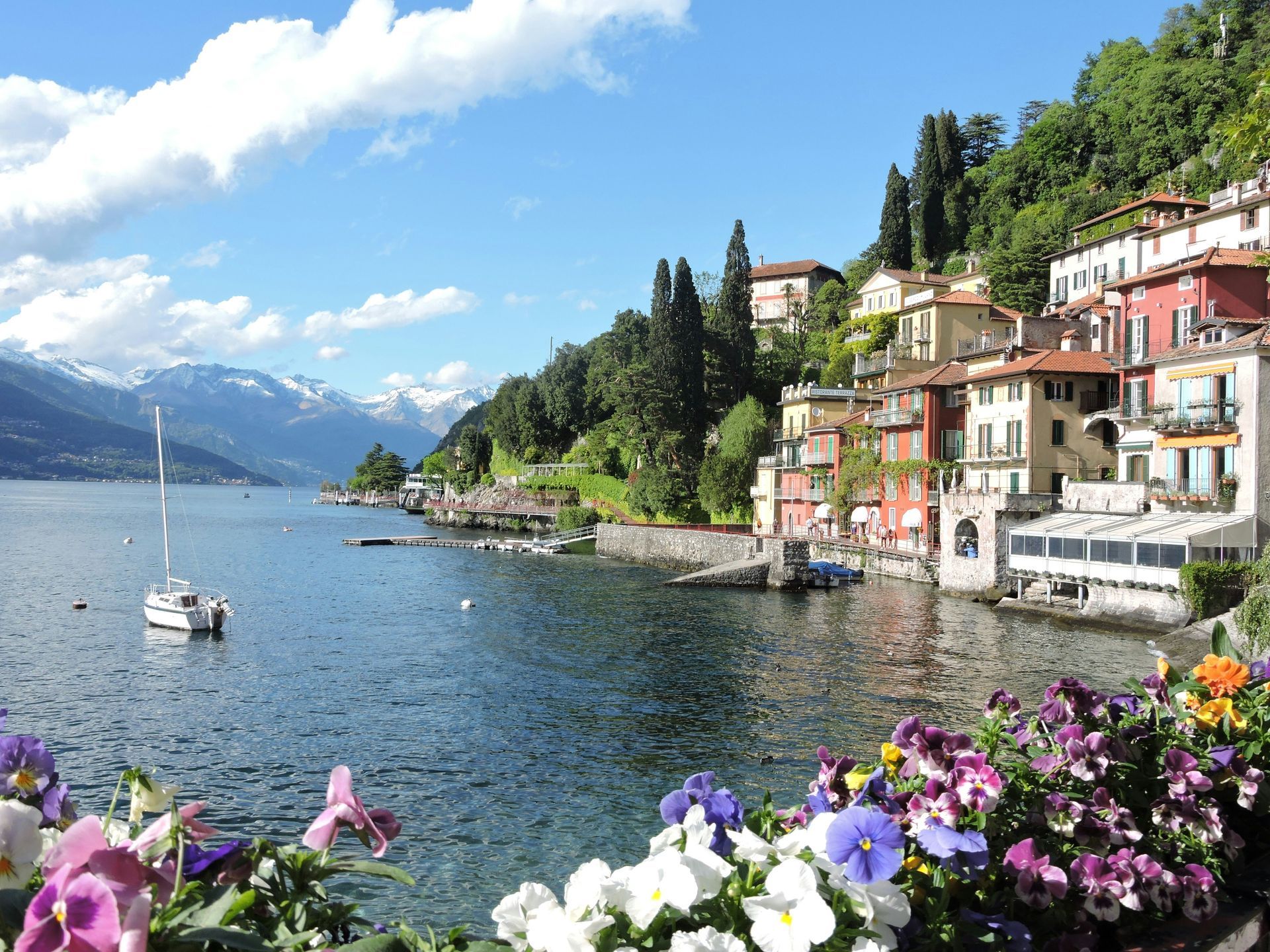 A view of Lake Como surrounded by buildings and flowers in Italy.