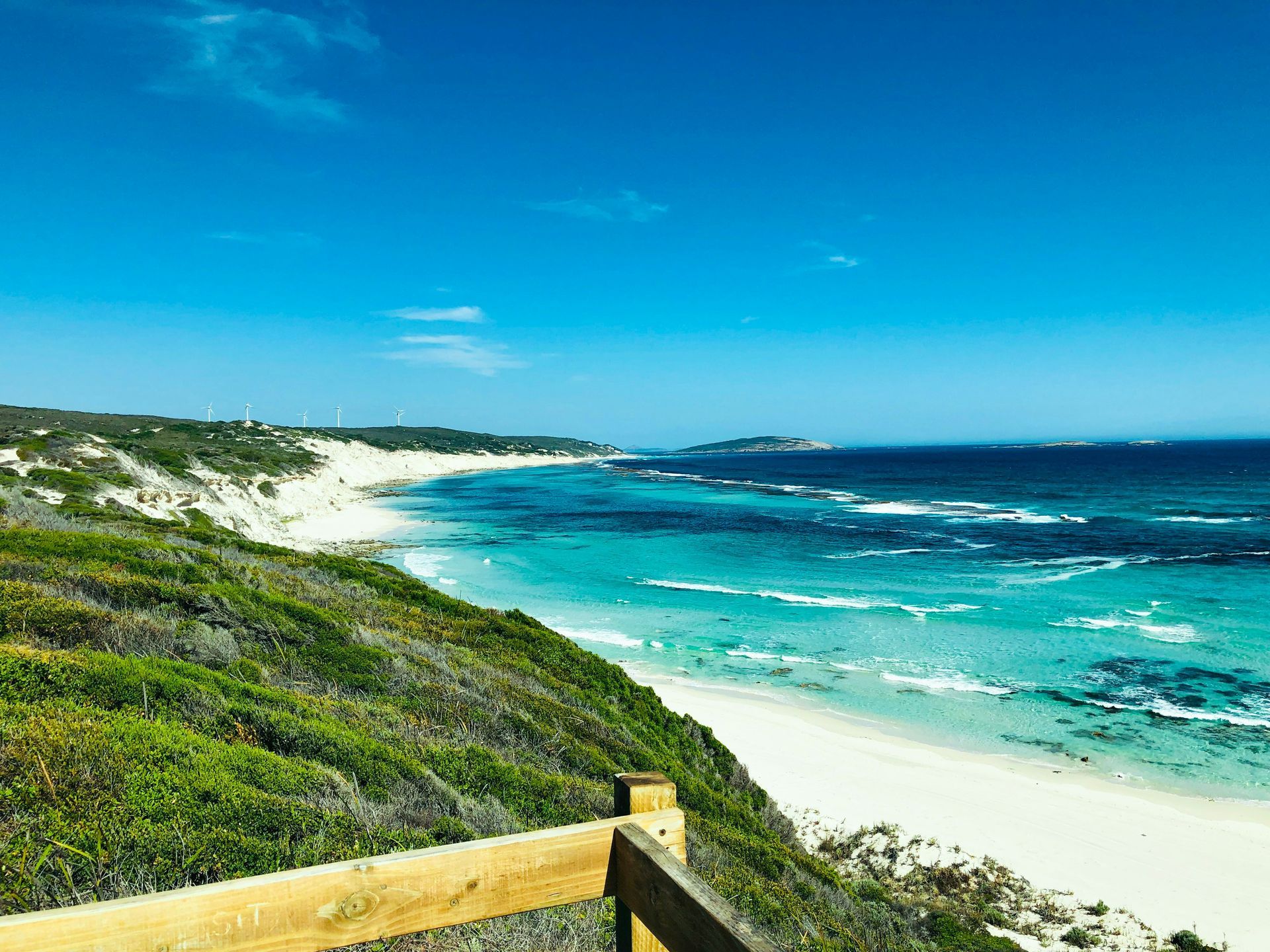 A view of a beach from a wooden fence in Western Australia.