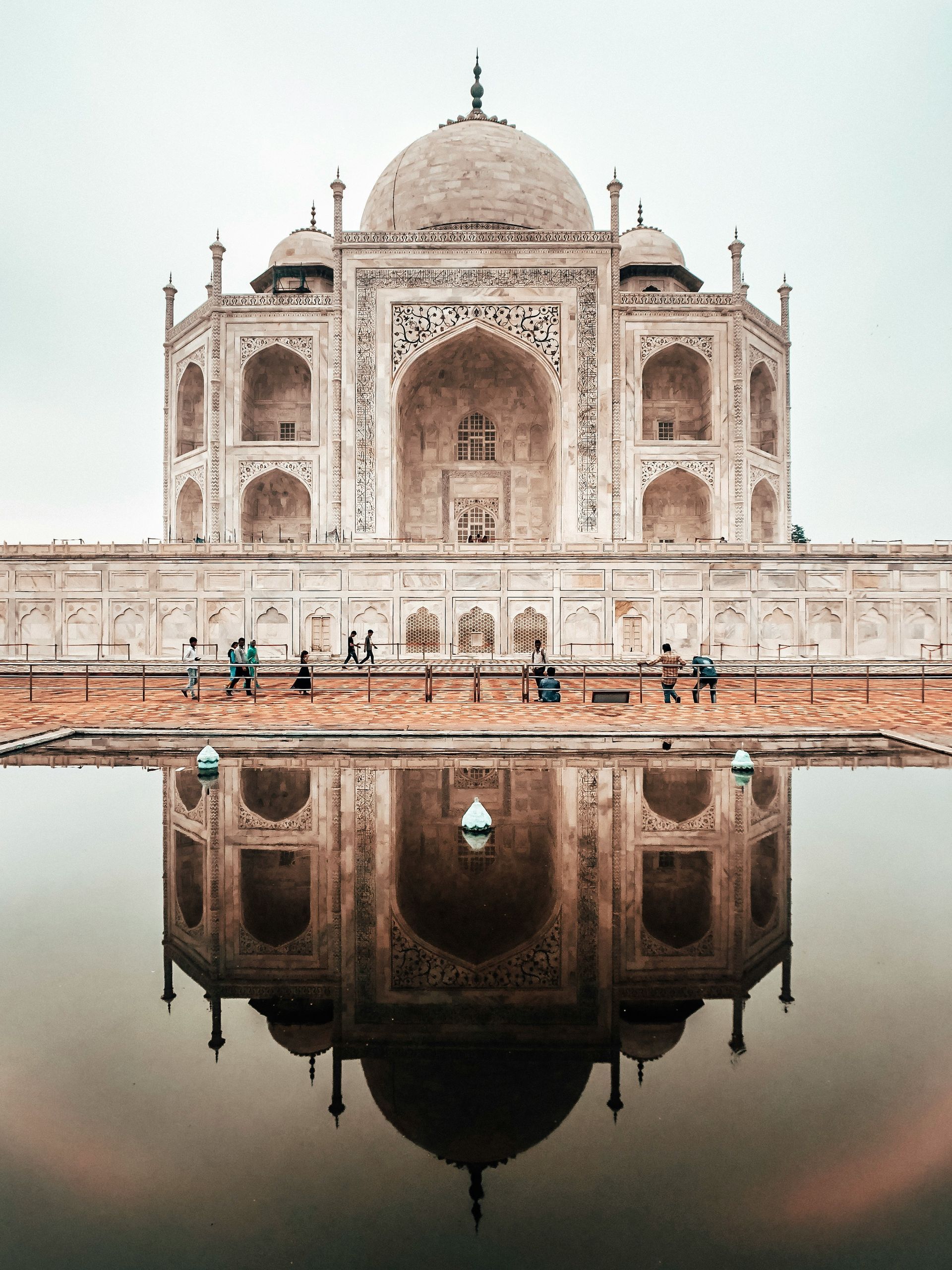 A large building is reflected in a body of water.