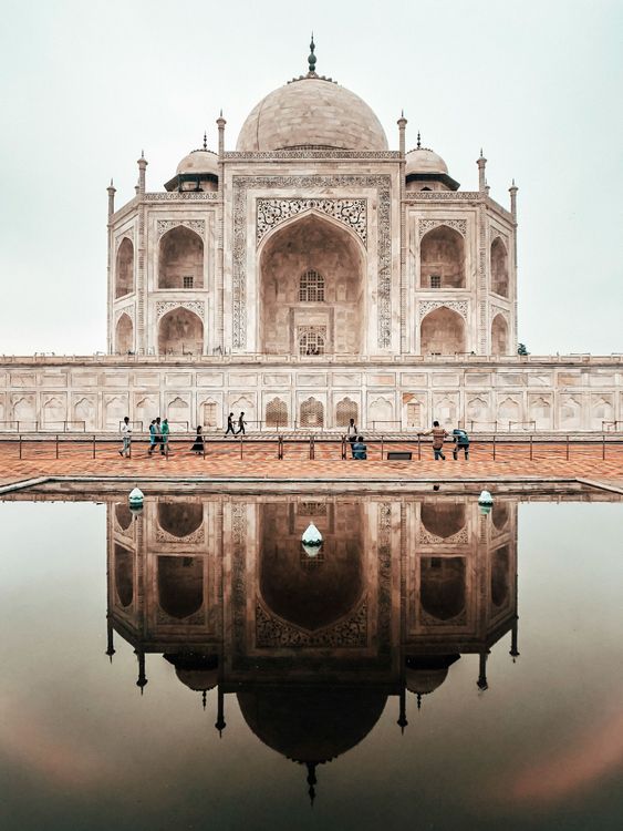 A large building is reflected in a body of water.