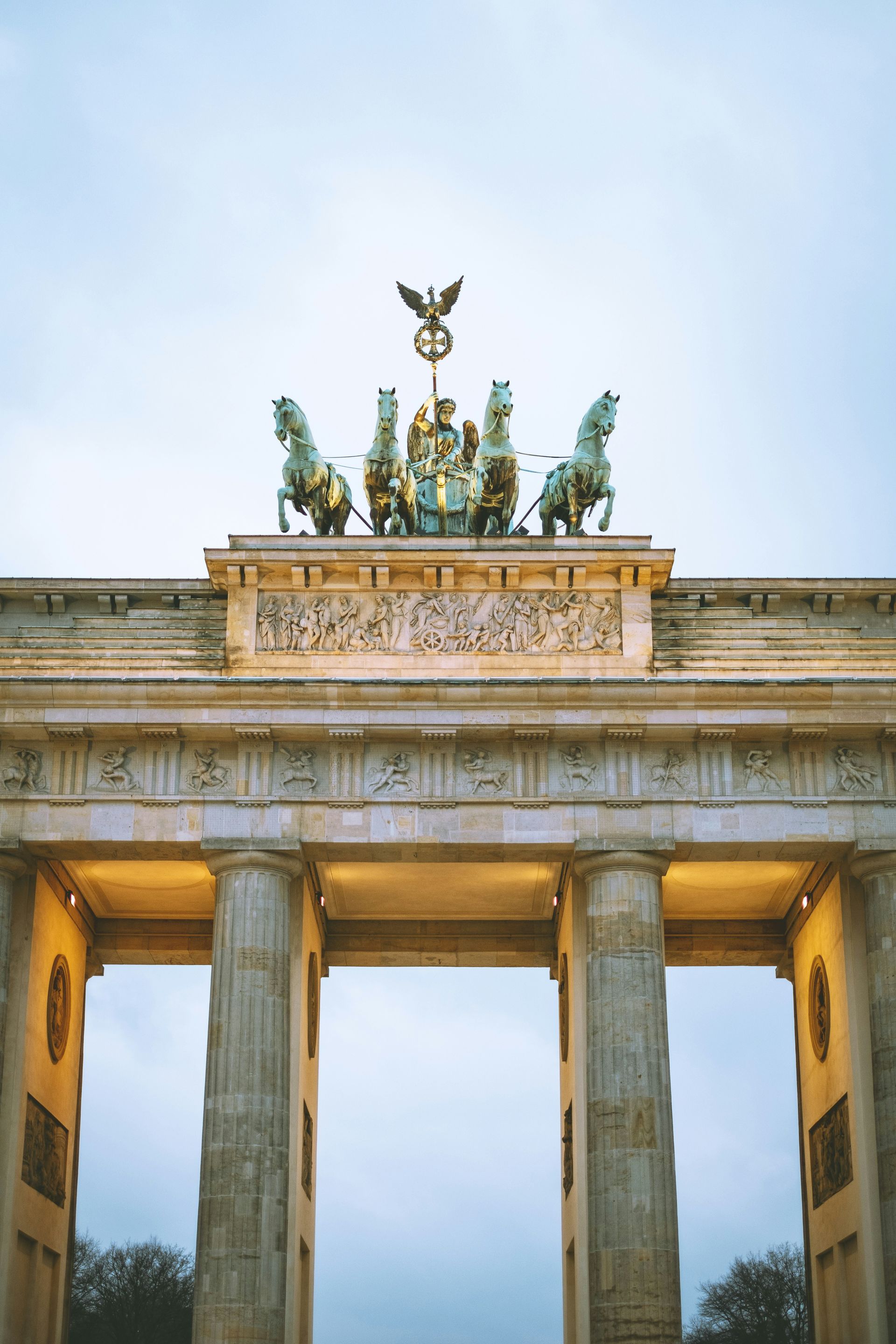 Brandenburg Gate in Berlin, Germany; a neoclassical monument with a chariot statue against a cloudy sky.