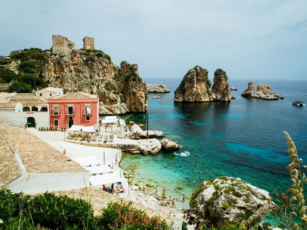 A small town in the middle of the ocean with a red building in the foreground.