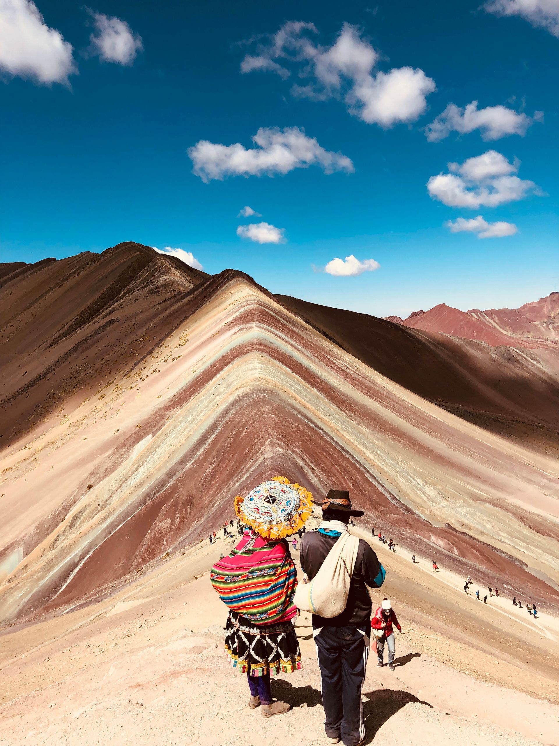 A man and a woman are walking up a mountain.