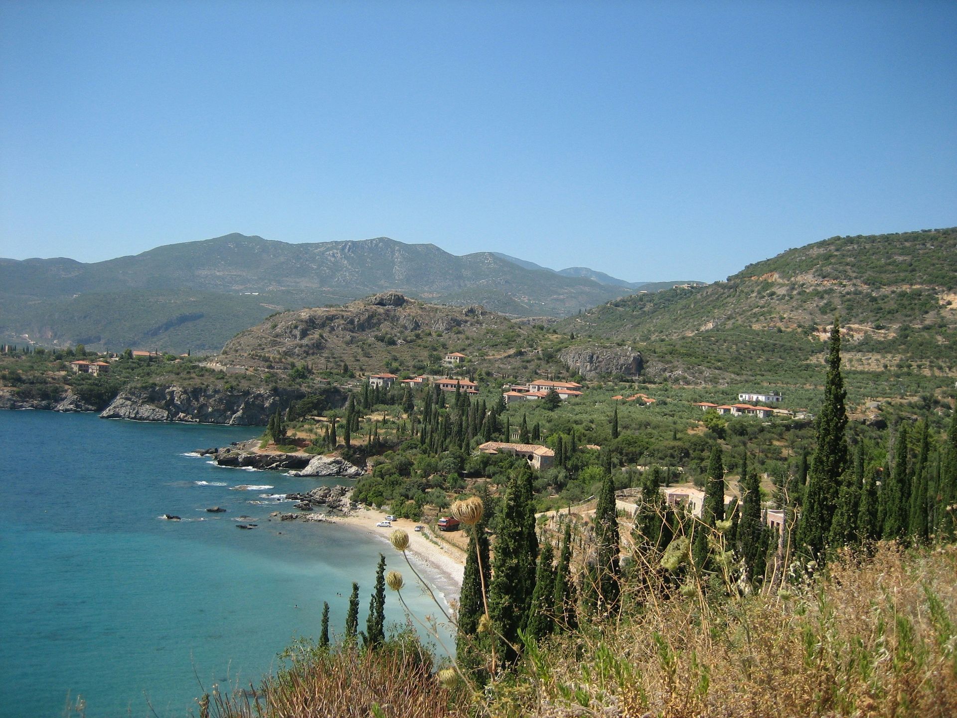 A view of a beach with mountains in the background in Peloponnese, Greece.
