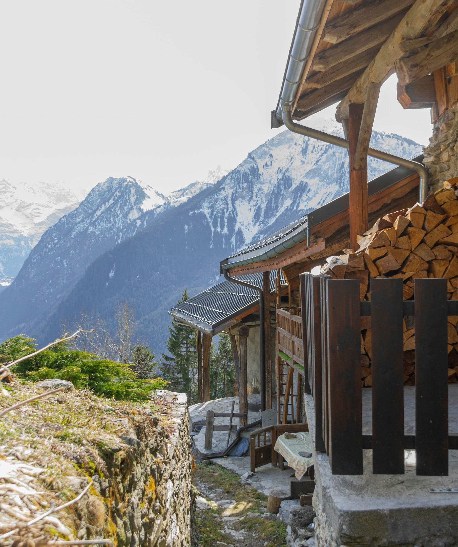 A house with a fence and mountains in the background in the French Alps.