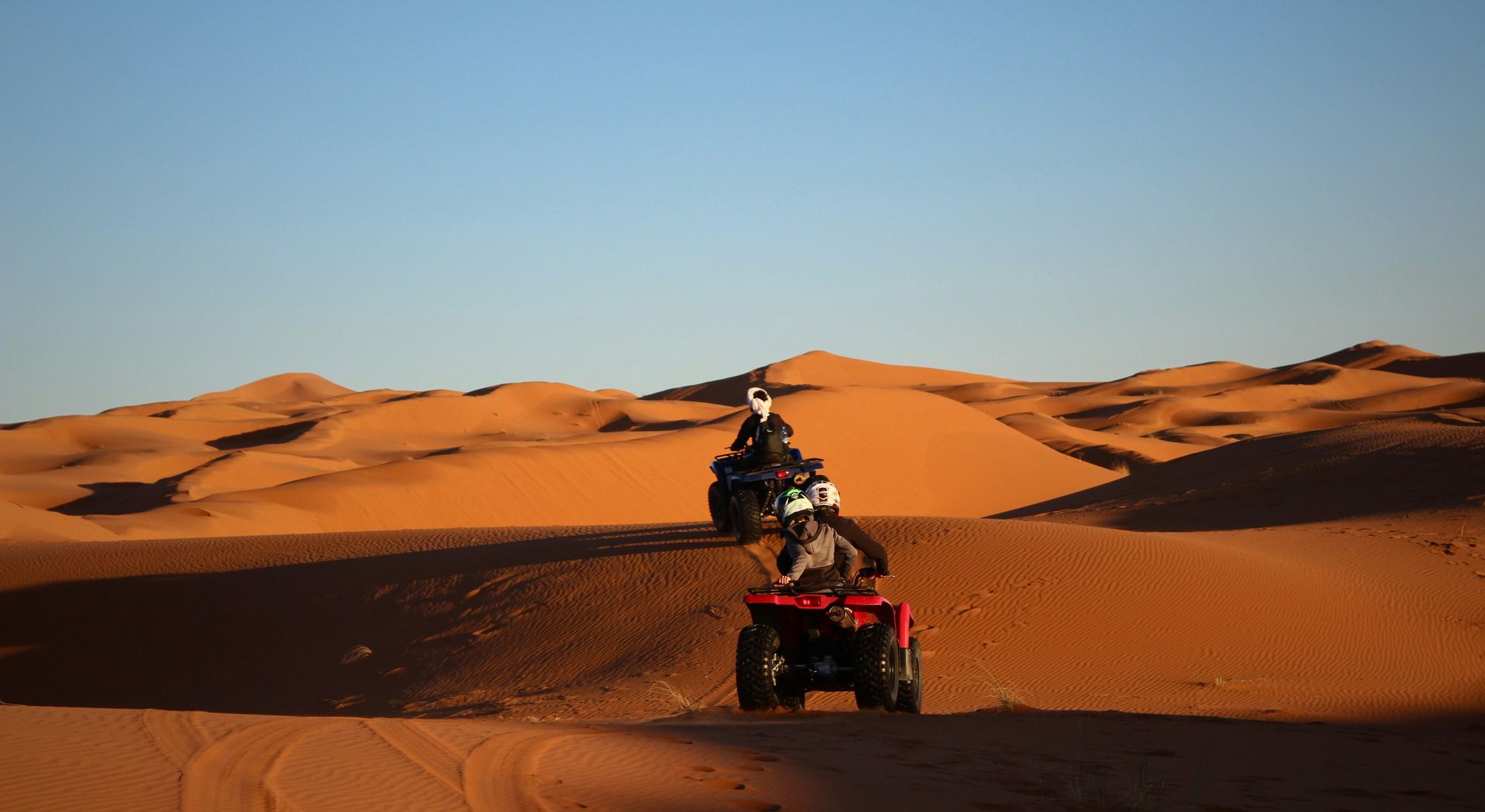 A person is riding an atv in the desert in Erg Chebbi, Morocco.