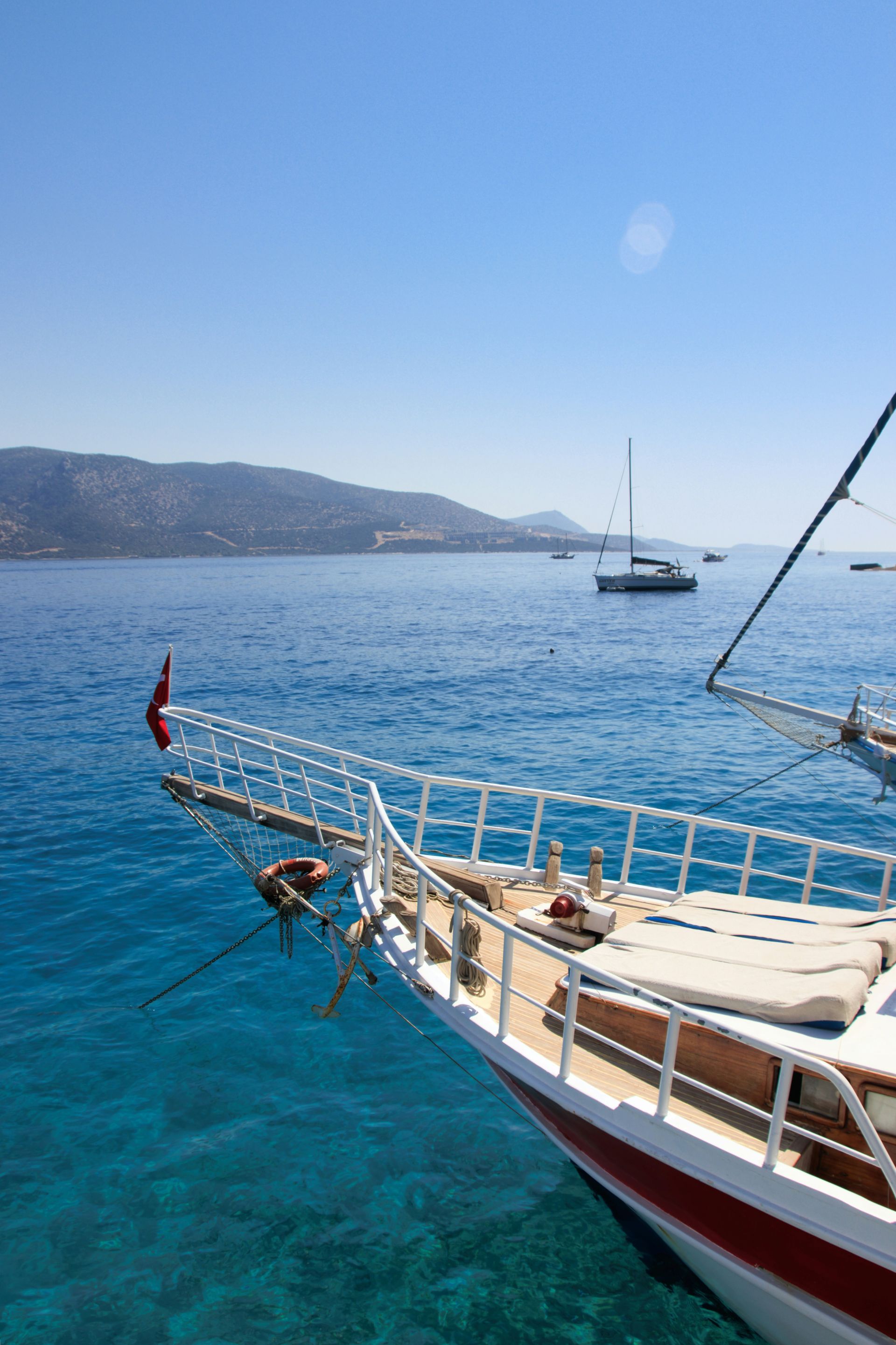 Sailboat bow on turquoise water, with distant shoreline in Bodrum, Turkey.