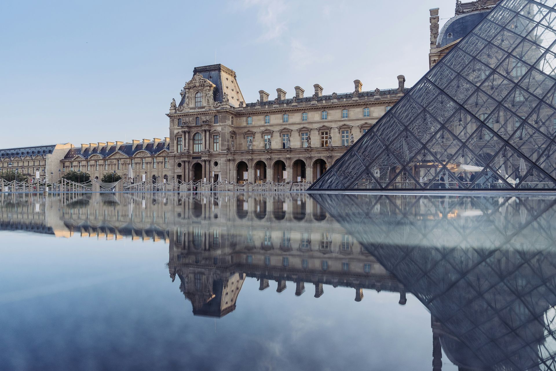 The Louvre museum is reflected in a body of water in Paris, France.