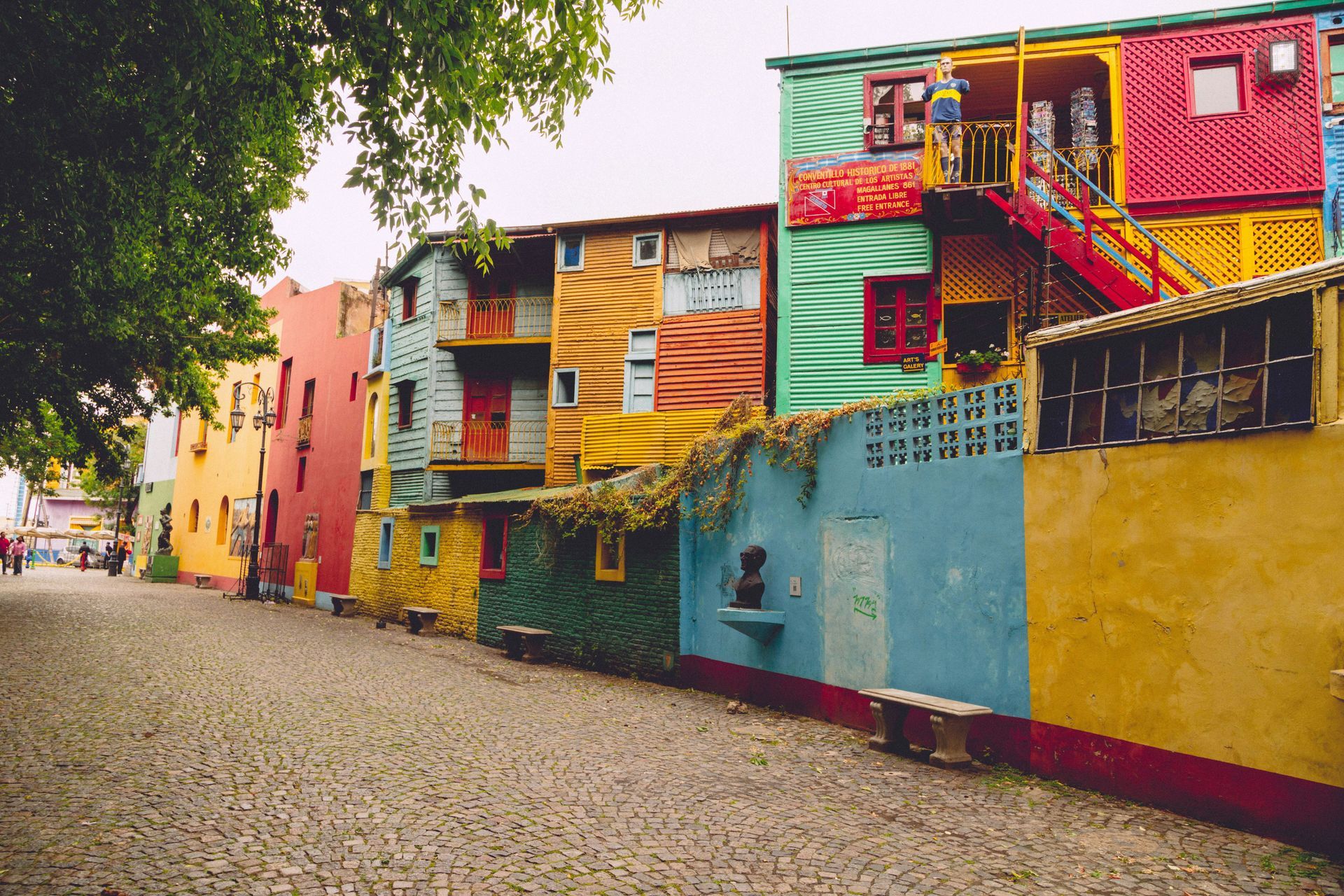 Colorful houses line a cobblestone street in La Boca, Buenos Aires.