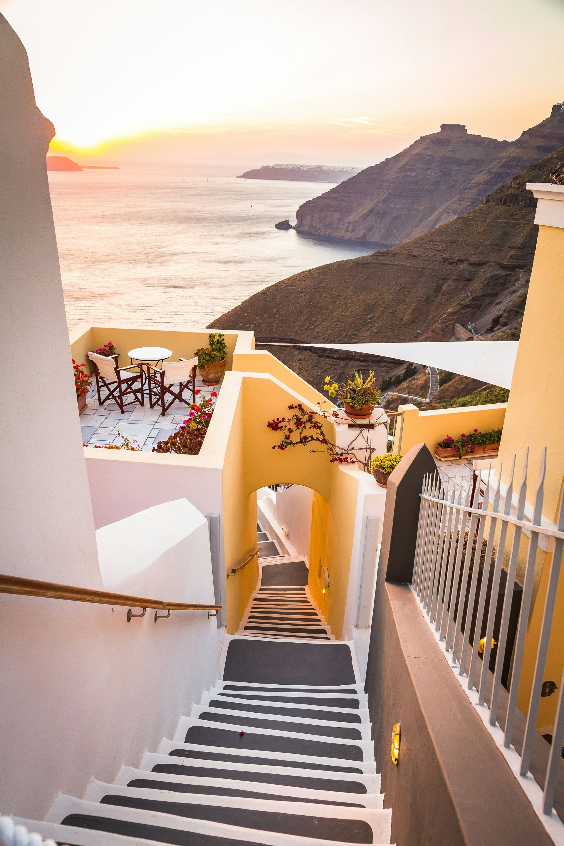 A set of stairs leading up to a balcony overlooking the ocean in Santorini, Greece.