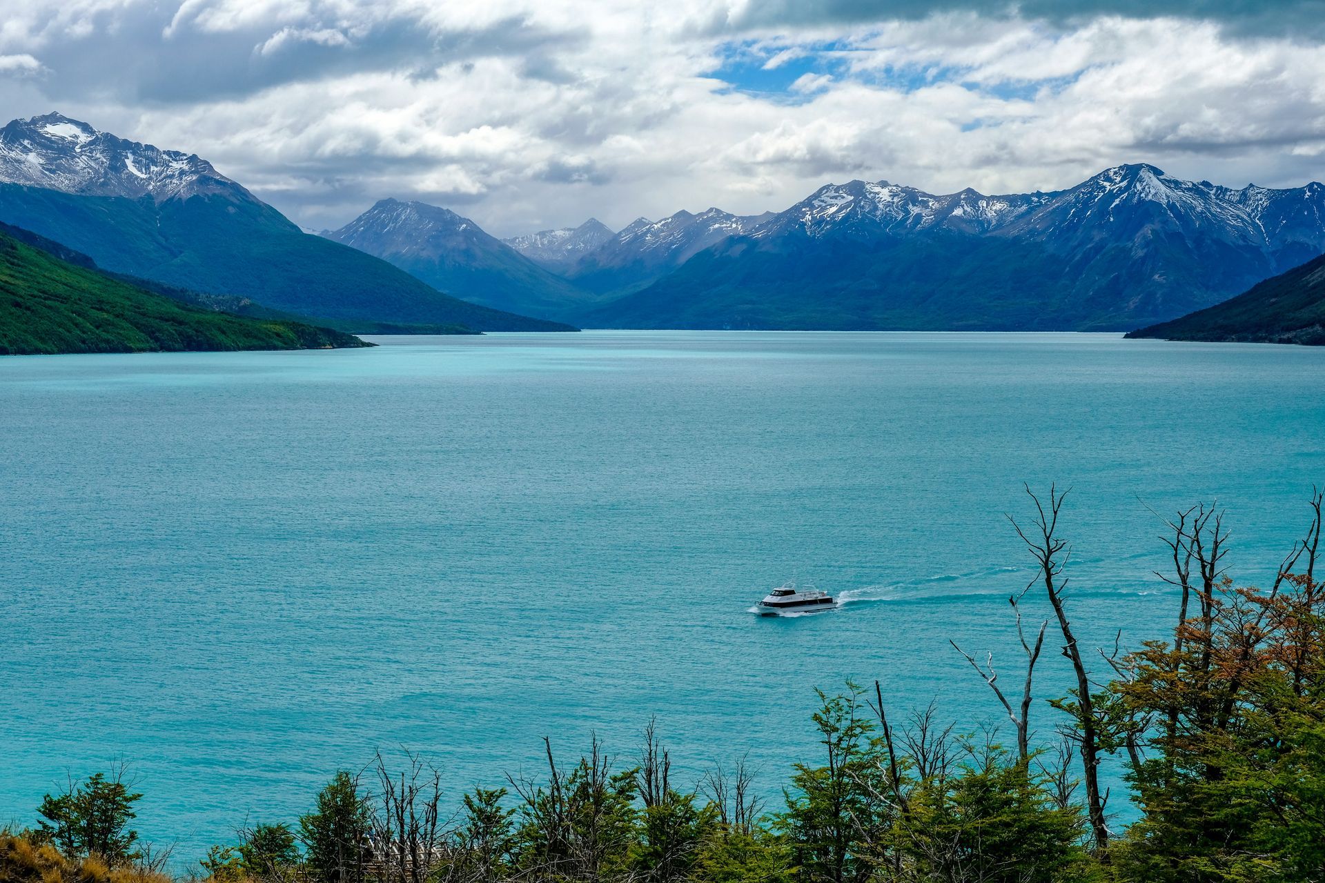 Turquoise Lake surrounded by snow-capped mountains at Parque Nacional Los Glaciares in El Calafate, Argentina.