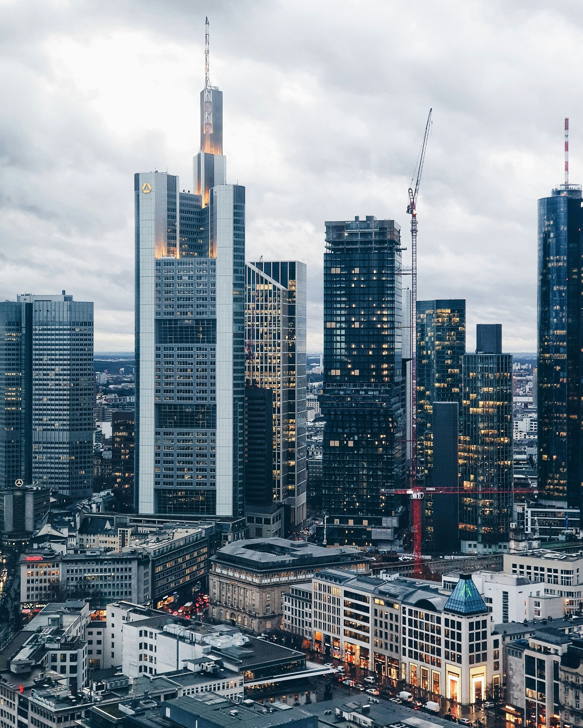 Frankfurt, Germany skyline with tall skyscrapers against a cloudy sky.