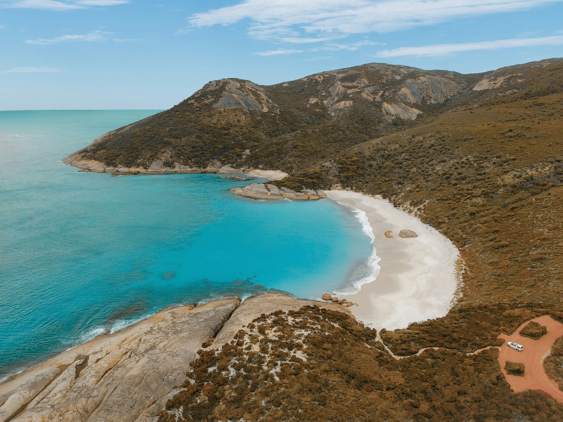 An aerial view of a beach surrounded by mountains and a body of water in Western Australia.