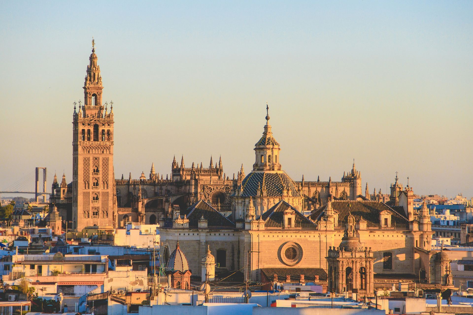 Seville Cathedral and Giralda tower, Spain. Golden hour sunlight bathes the historic buildings.