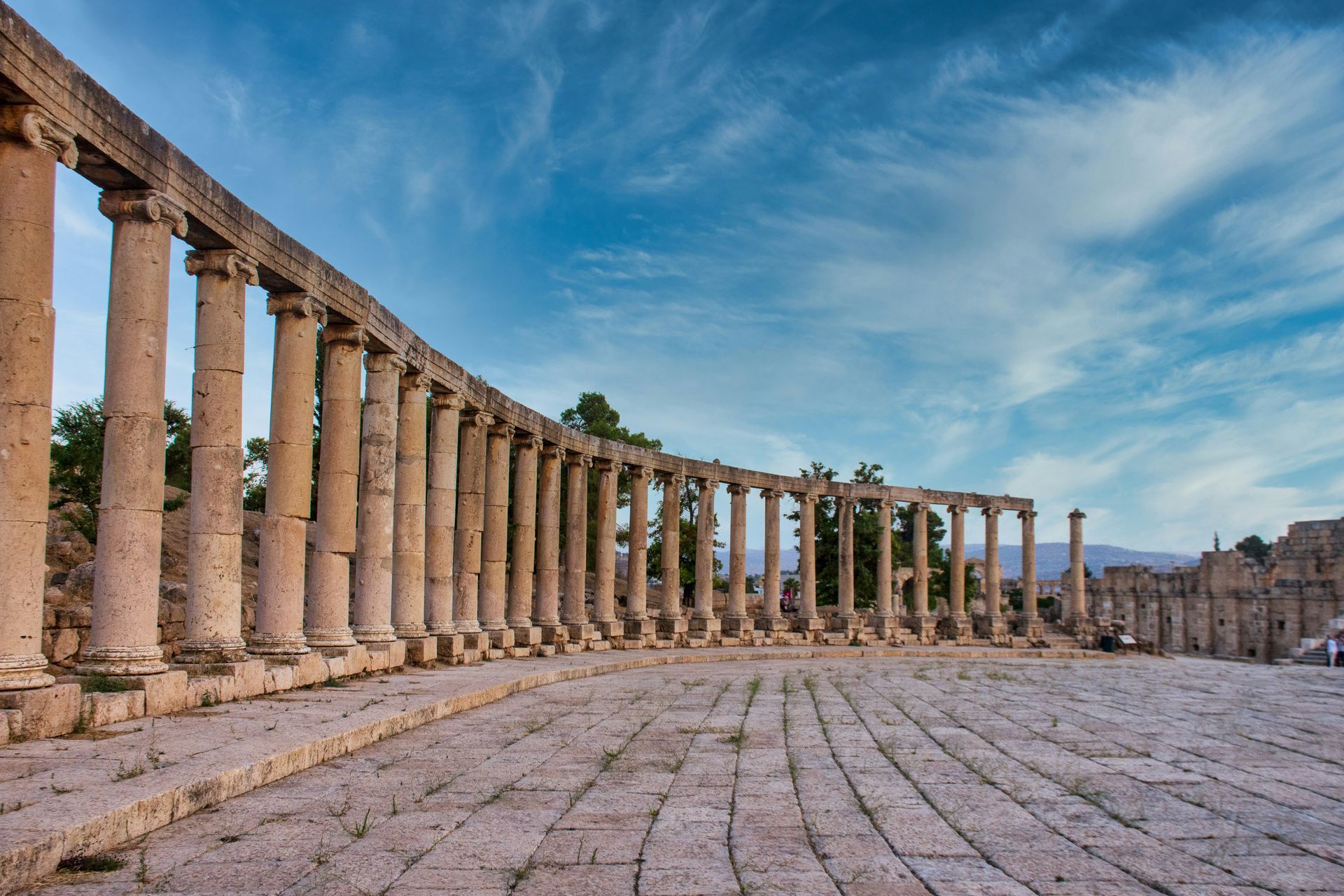 Row of Roman columns in an ancient, paved plaza in Jerash, Jordan.