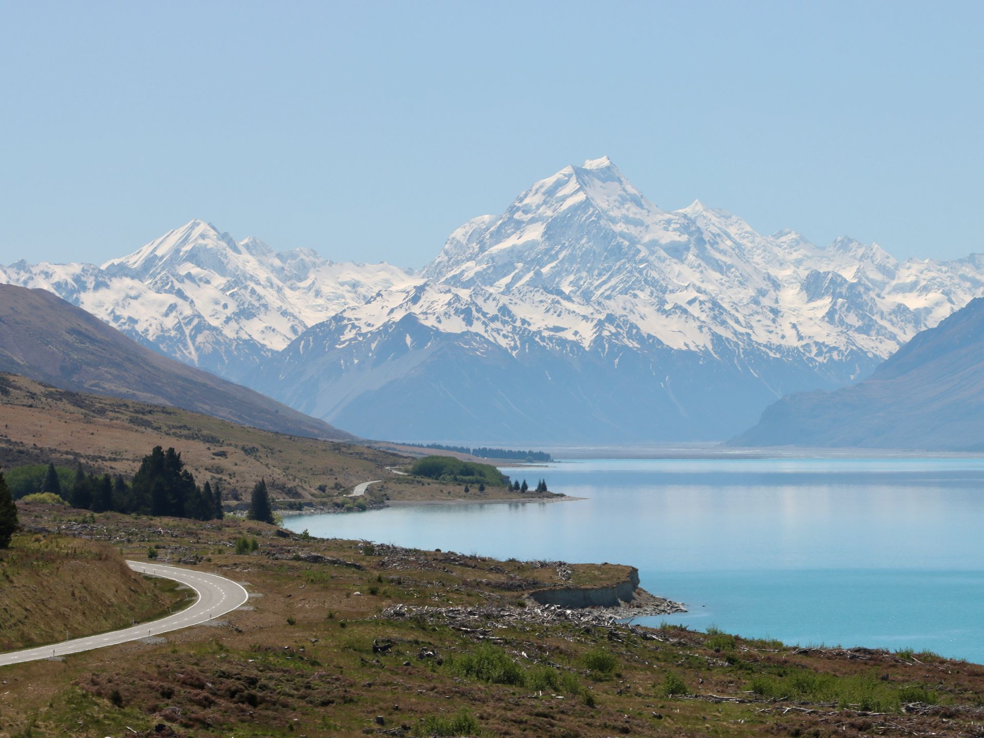 Lake Pukaki with Mount Cook in the background and a road going through it in New Zealand.