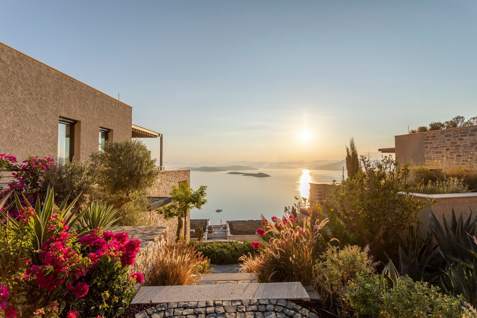 Stone buildings overlook a calm sea as the sun sets in Bodrum, Turkey.