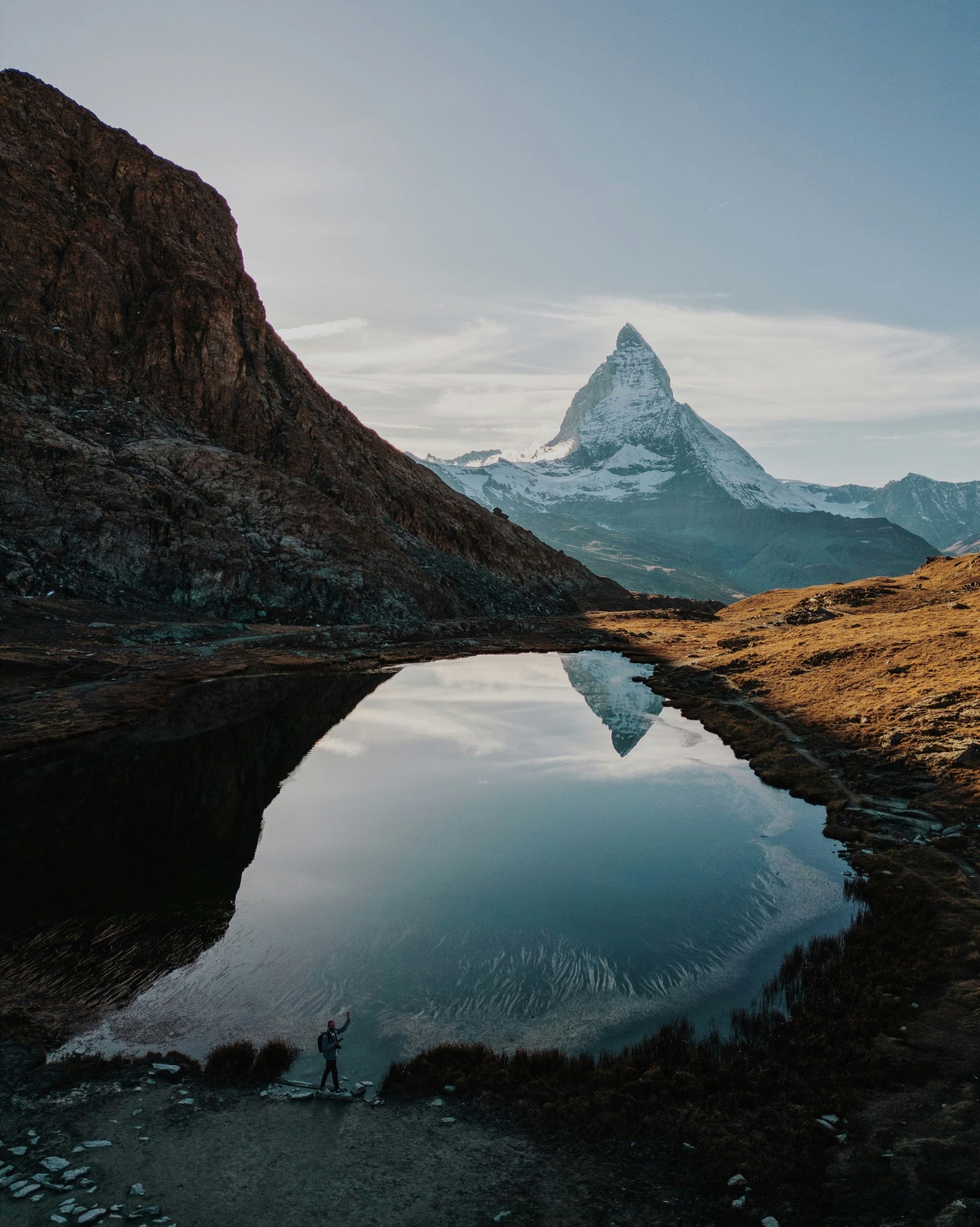 Snow-capped Matterhorn mountain reflected in a small pool of water in Zermatt, Switzerland.