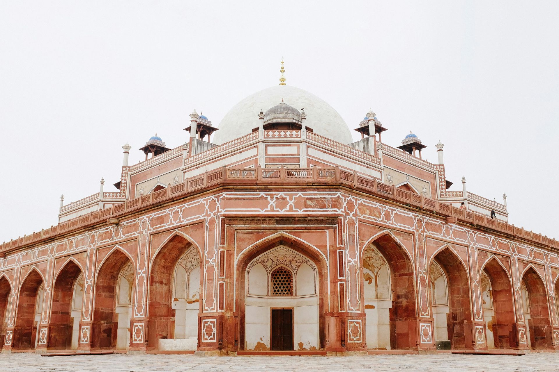 Humayun's Tomb in Delhi, India: red sandstone and white marble Mughal architecture under a cloudy sky.