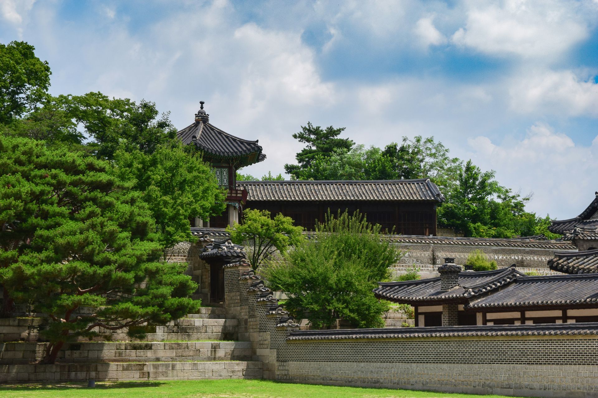 Changdeokgung Palace with tiled roofs, stone walls, and surrounding greenery in South Korea.