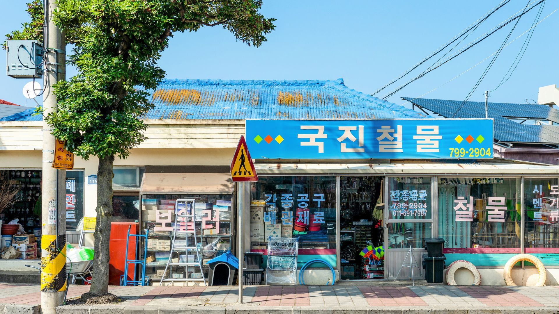 A hardware store in South Korea with blue tiled roof and storefront display on Jeju Island, South Korea.