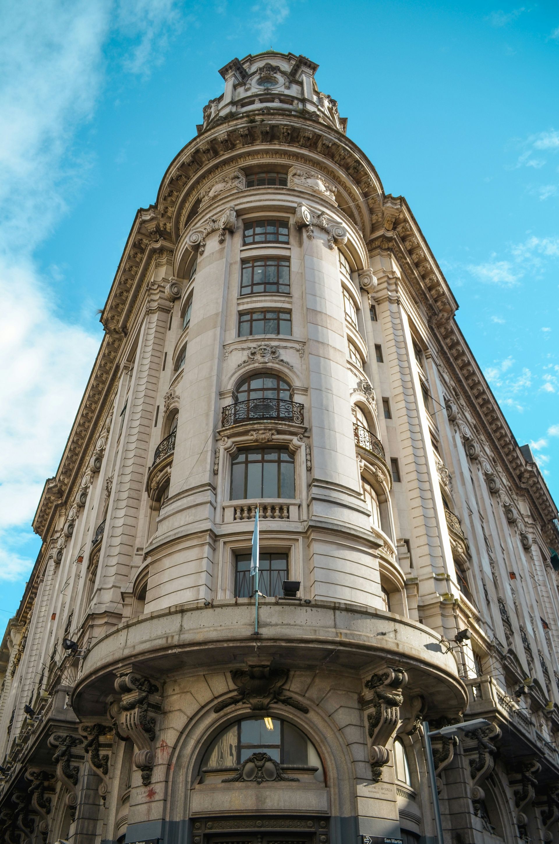 Ornate, cream-colored building with many windows and decorative details, against the sky in Buenos Aires, Argentina.