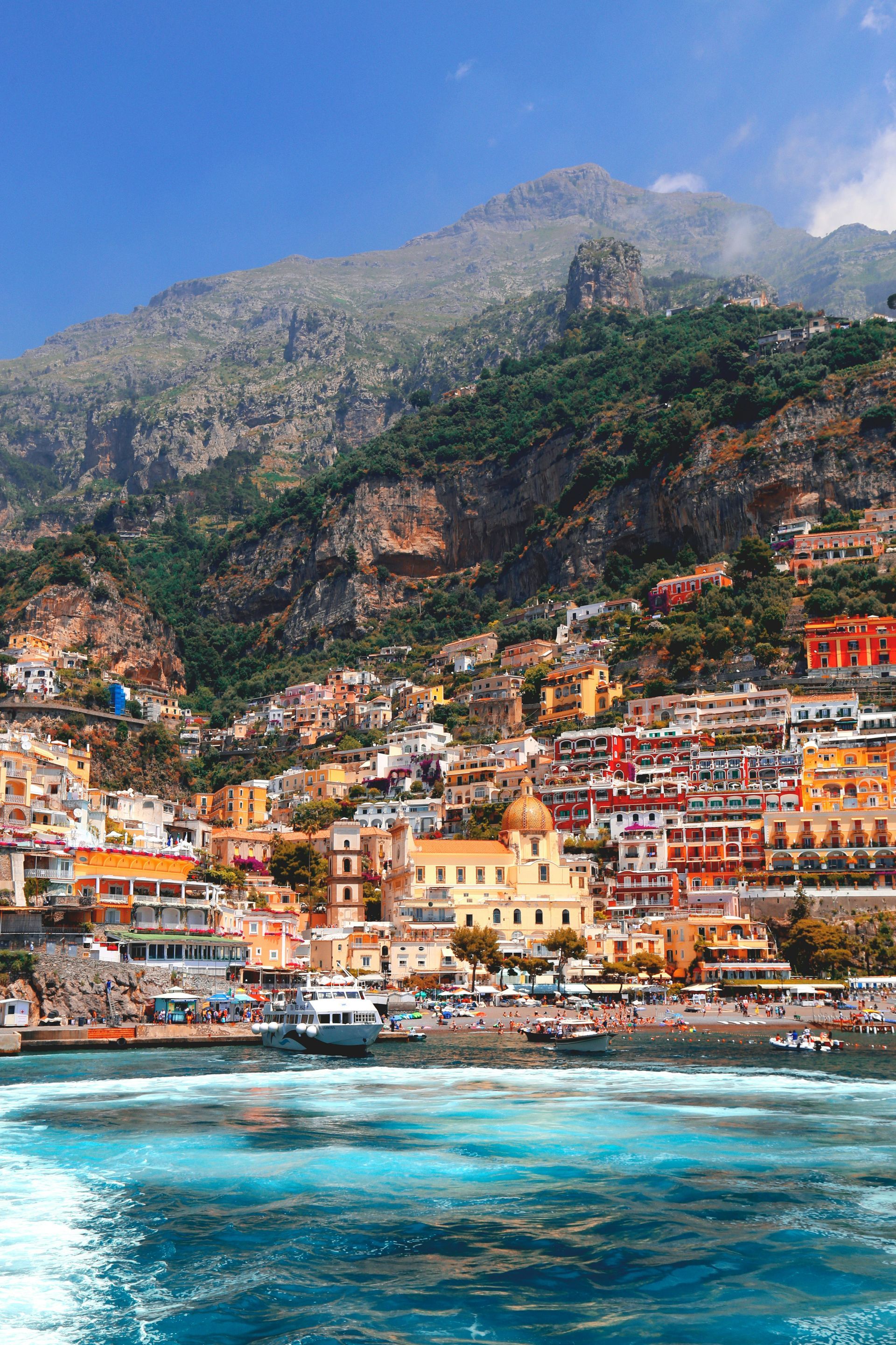 A view of a city from the water with a mountain in the background.